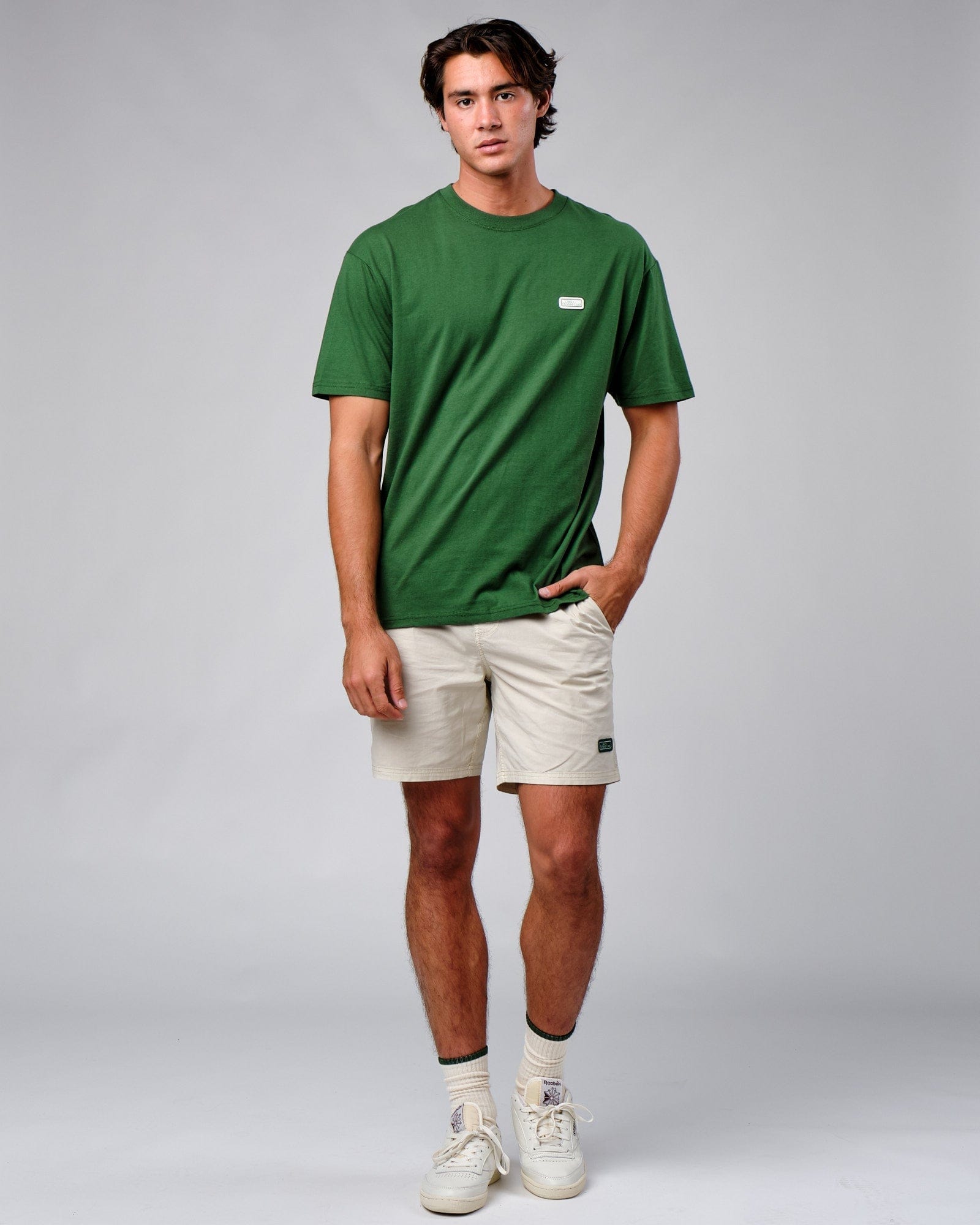 Model wearing Badge Tee Oversize - Eden Green