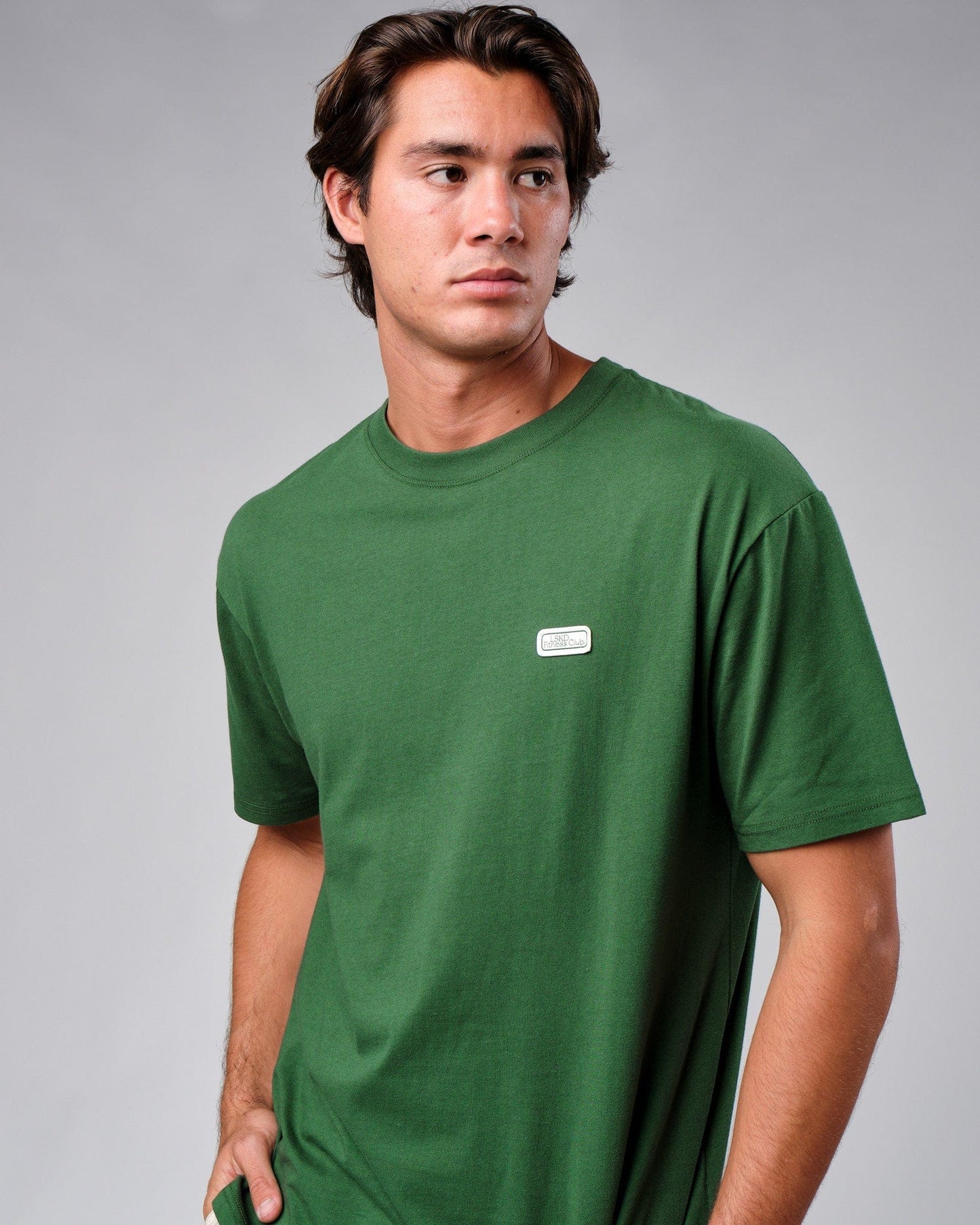 Model wearing Badge Tee Oversize - Eden Green