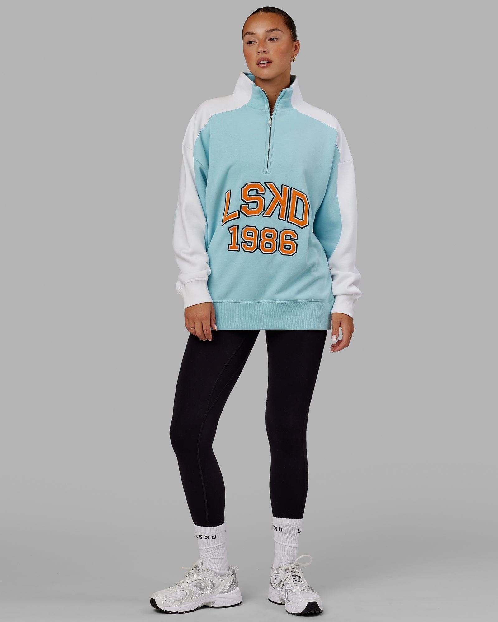 Model wearing Unisex Alumni 1/4 Zip Sweater Oversize - Crystal Blue-Orange Peel