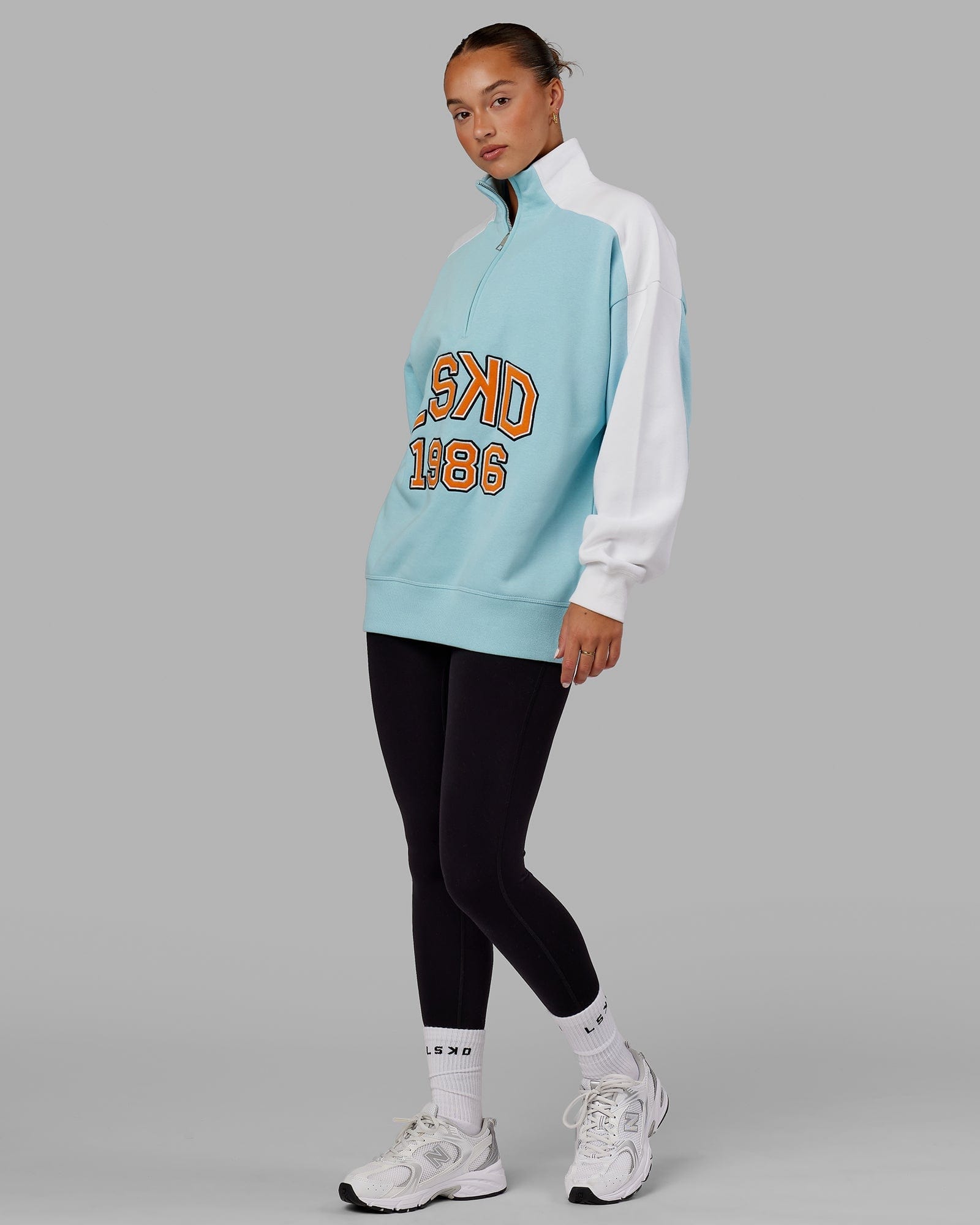 Model wearing Unisex Alumni 1/4 Zip Sweater Oversize - Crystal Blue-Orange Peel