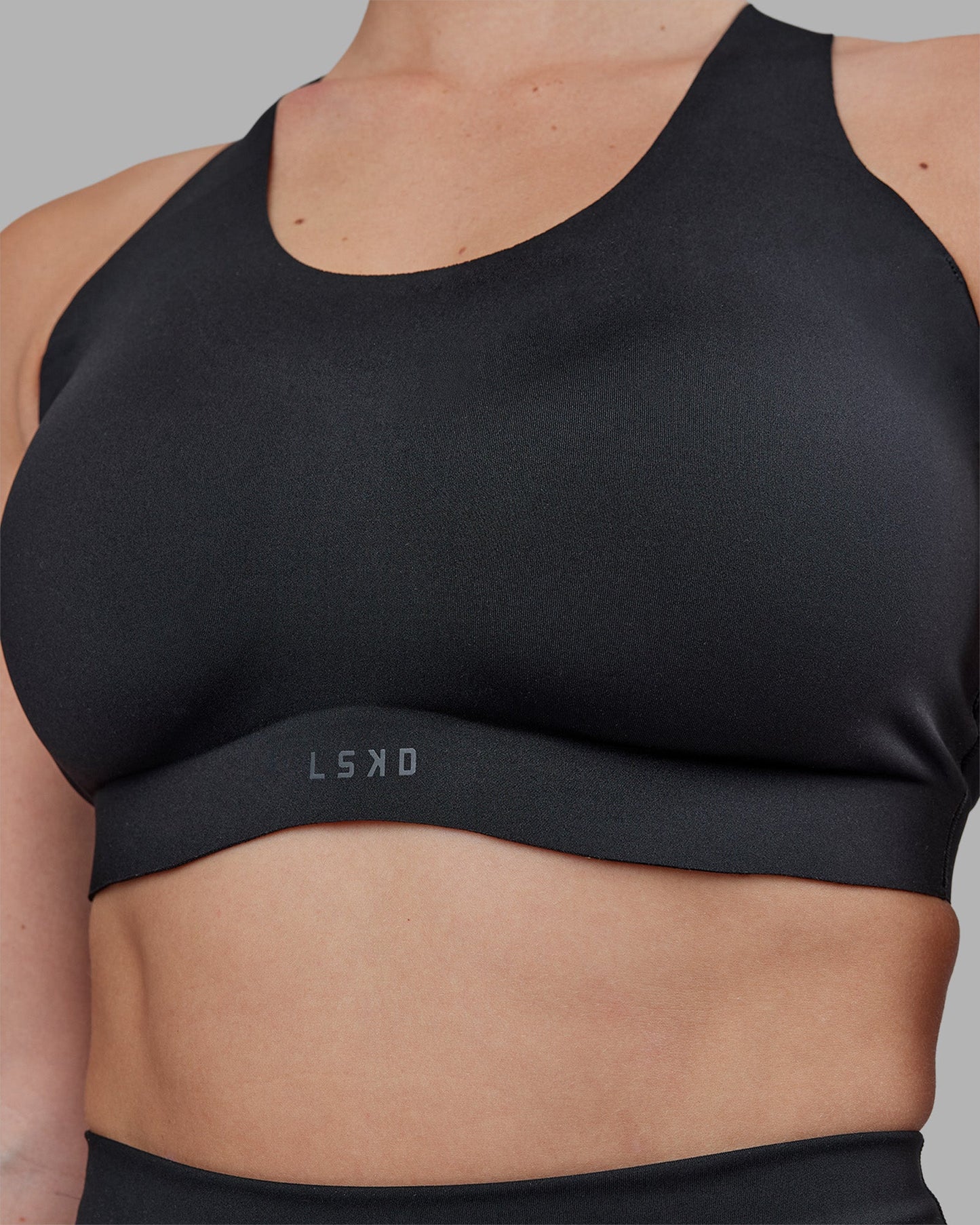 Woman wearing Stability Sports Bra - Black | Model:Amy | Size:M (D-E Cup)