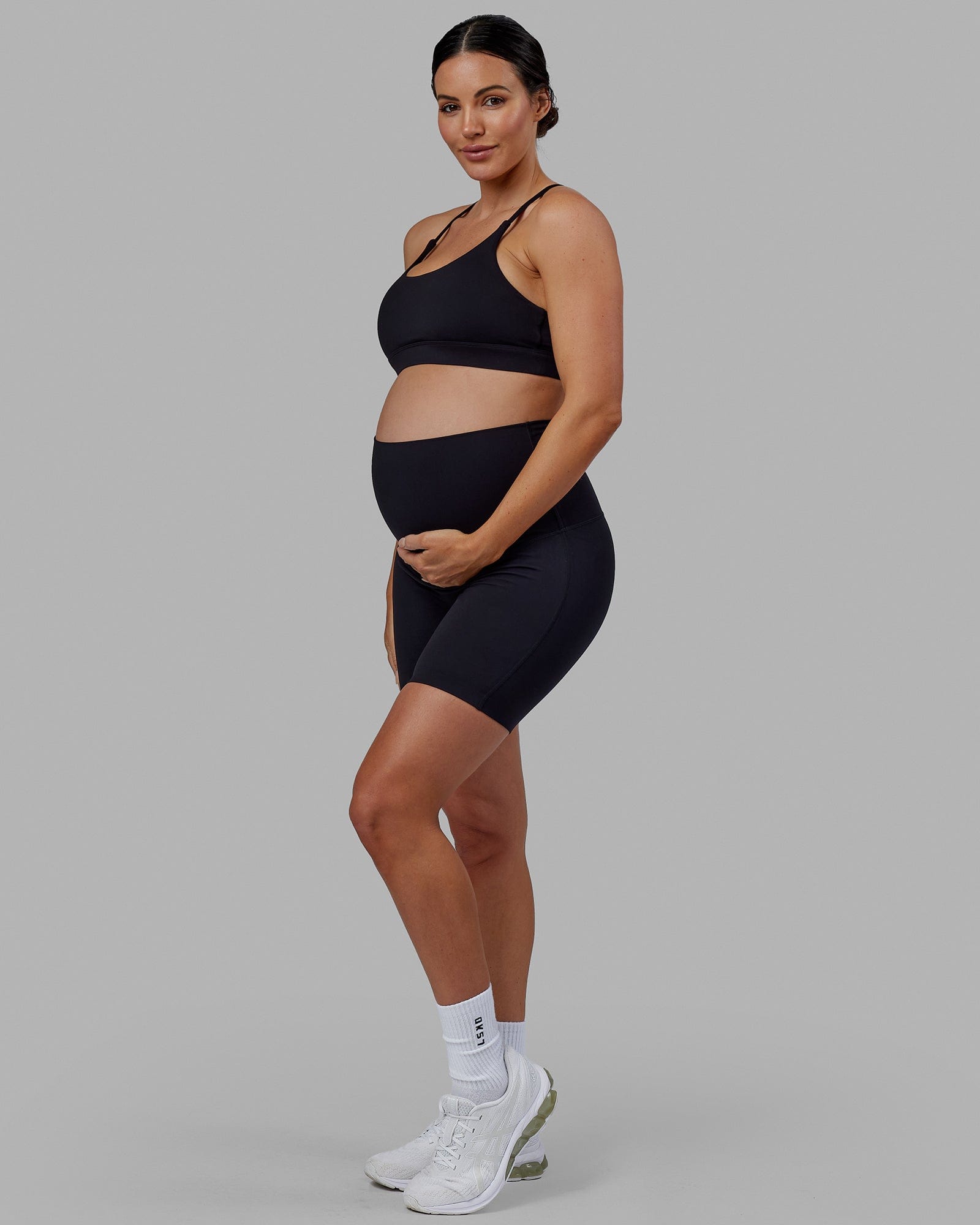 Woman wearing Elixir Mid Short Maternity Tight - Black