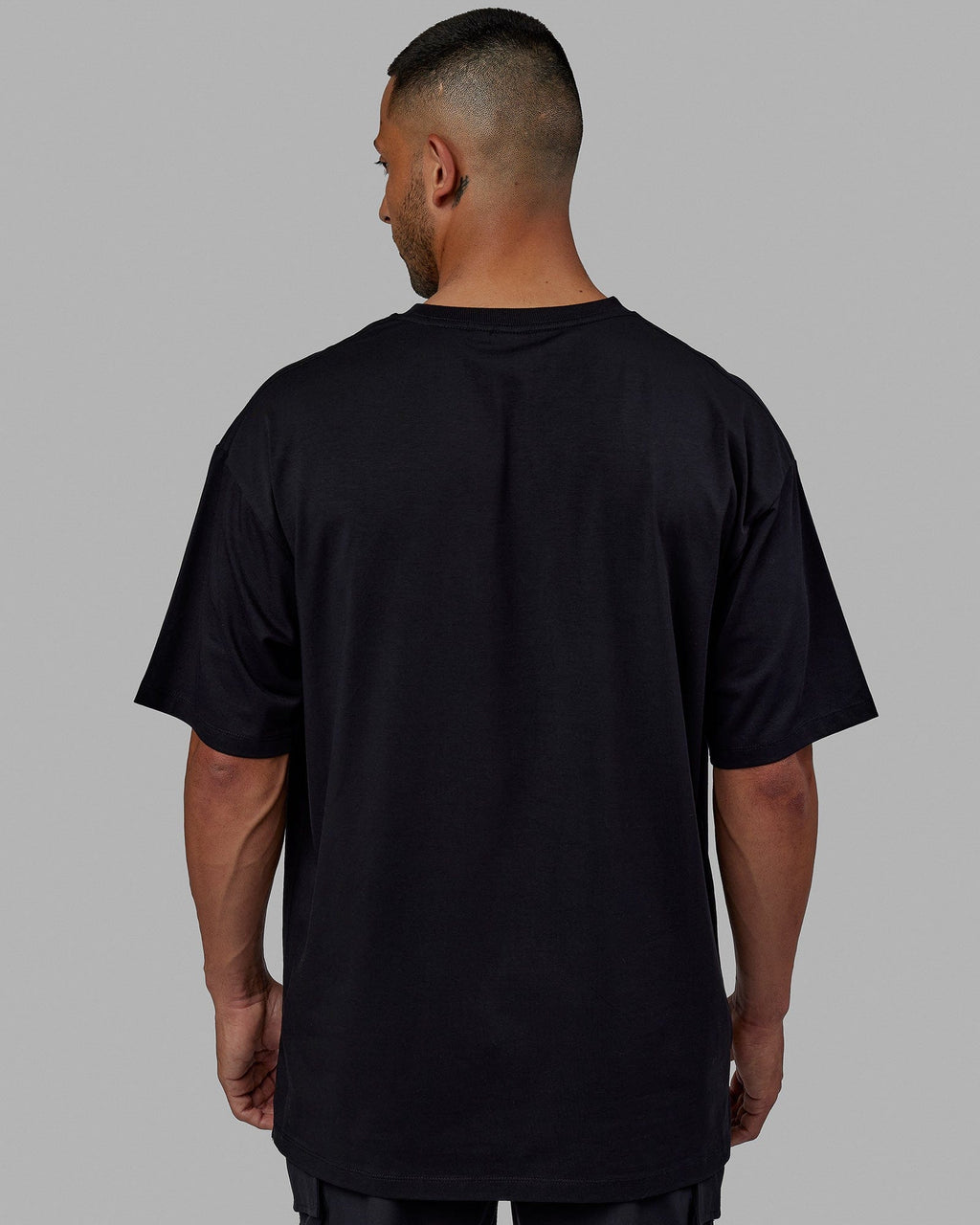 Man wearing Unisex PimaFLX Tee Oversize - Black