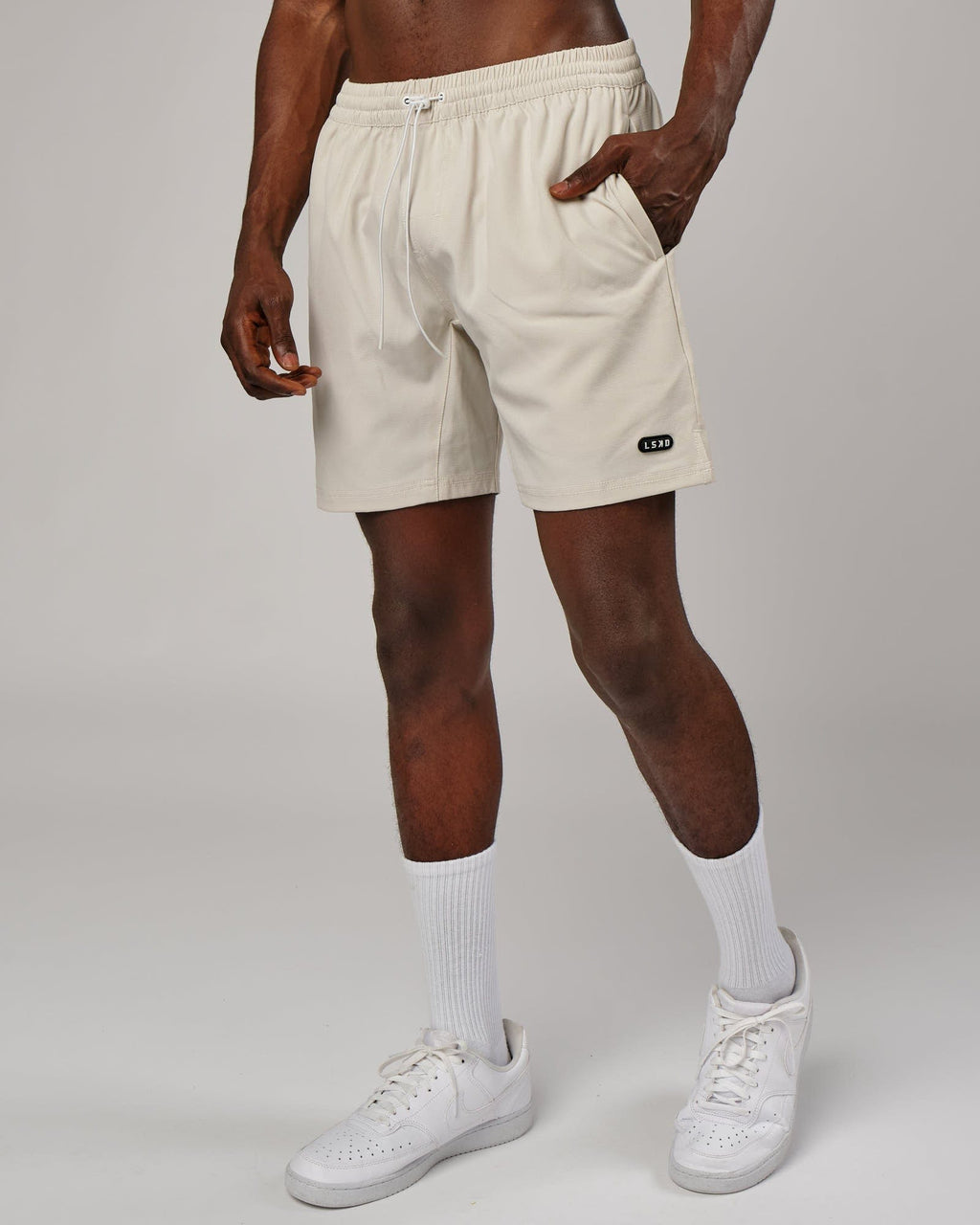Model wearing Capsule 7" Performance Short - Bone