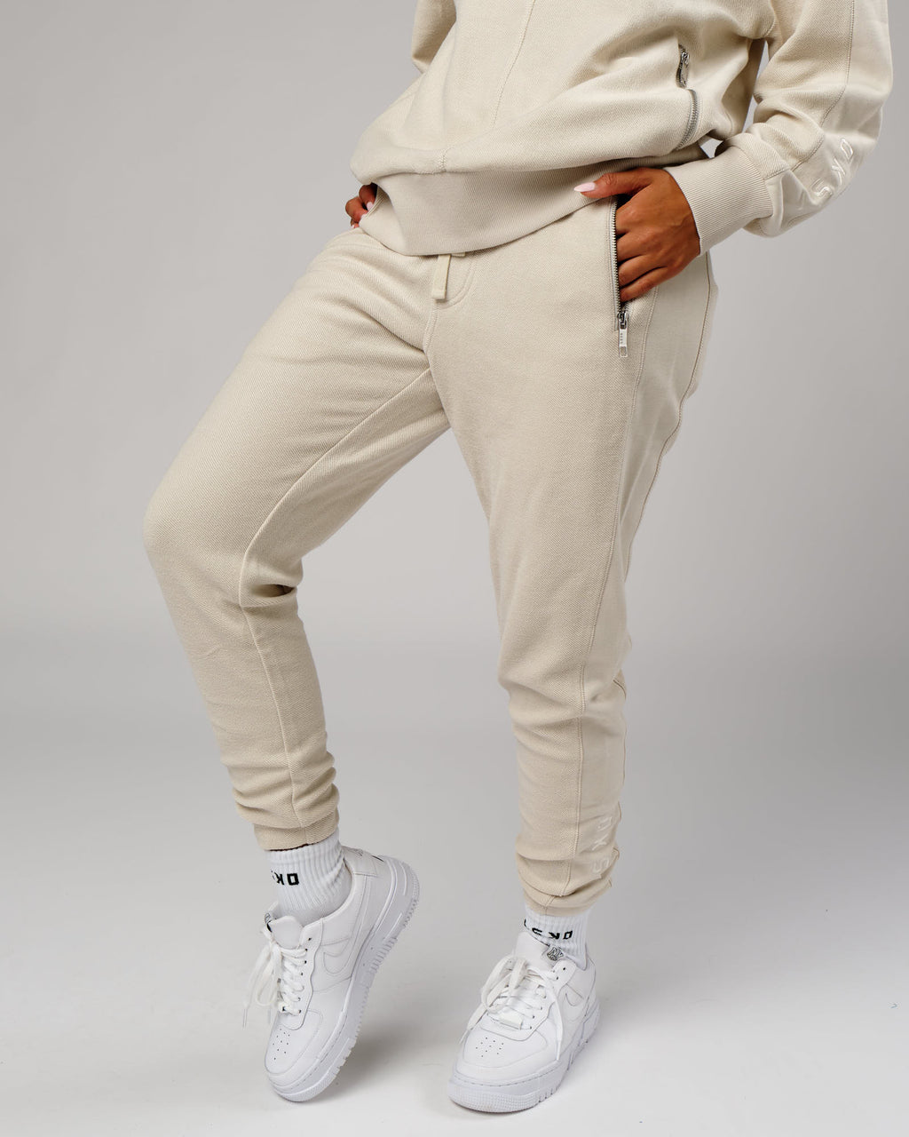 Model wearing Unisex Therma Track Pant - Bone