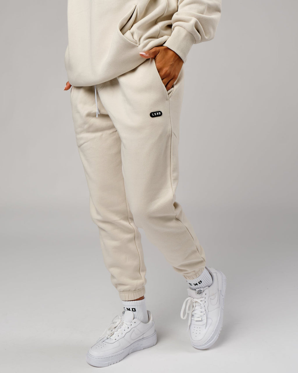 Model wearing Unisex Capsule Track Pant - Bone