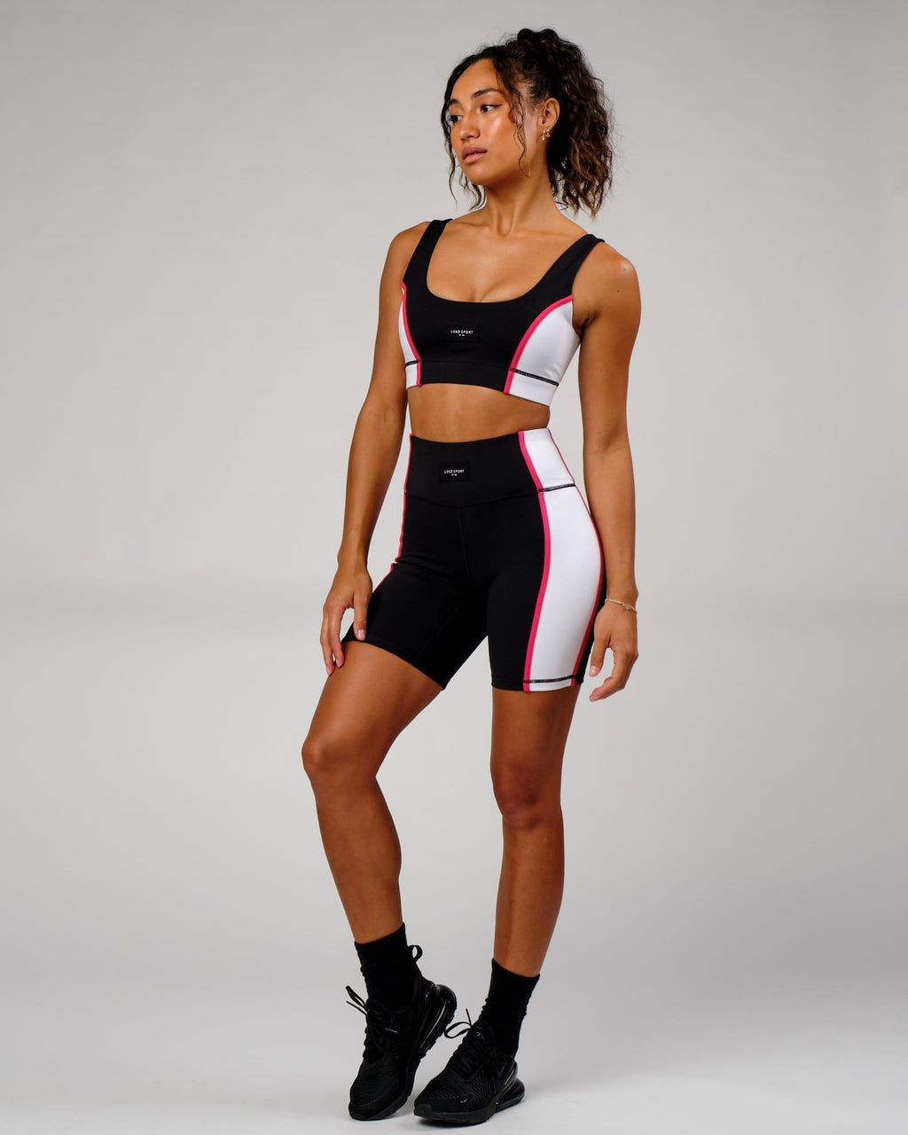 Model wearing Hunter Mid Short Tight - Black-White-Boysenberry