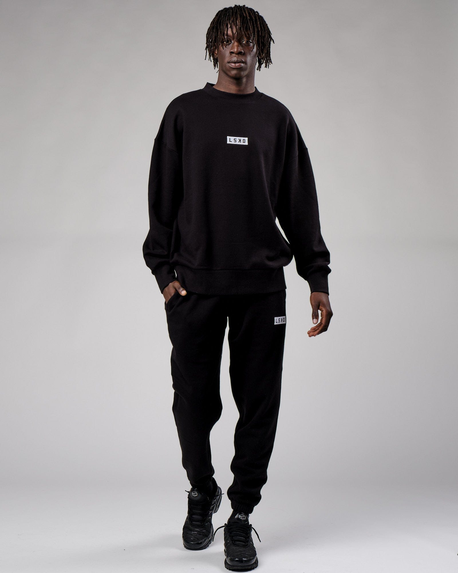 Model wearing Cornerstone Track Pant Oversize - Black