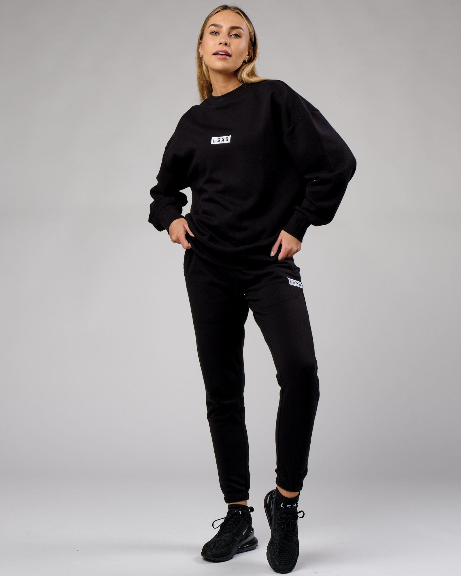 Model wearing Unisex Cornerstone Track Pant Oversize - Black