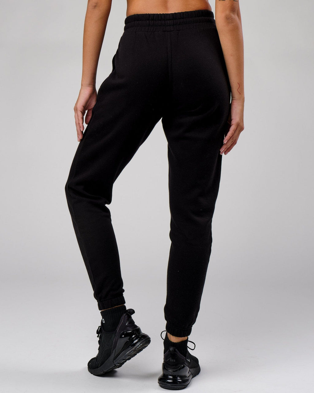 Model wearing Unisex Cornerstone Track Pant Oversize - Black