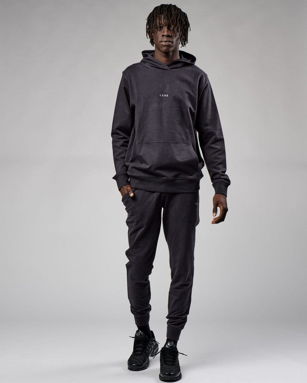 Model wearing Base Track Pant - Phantom