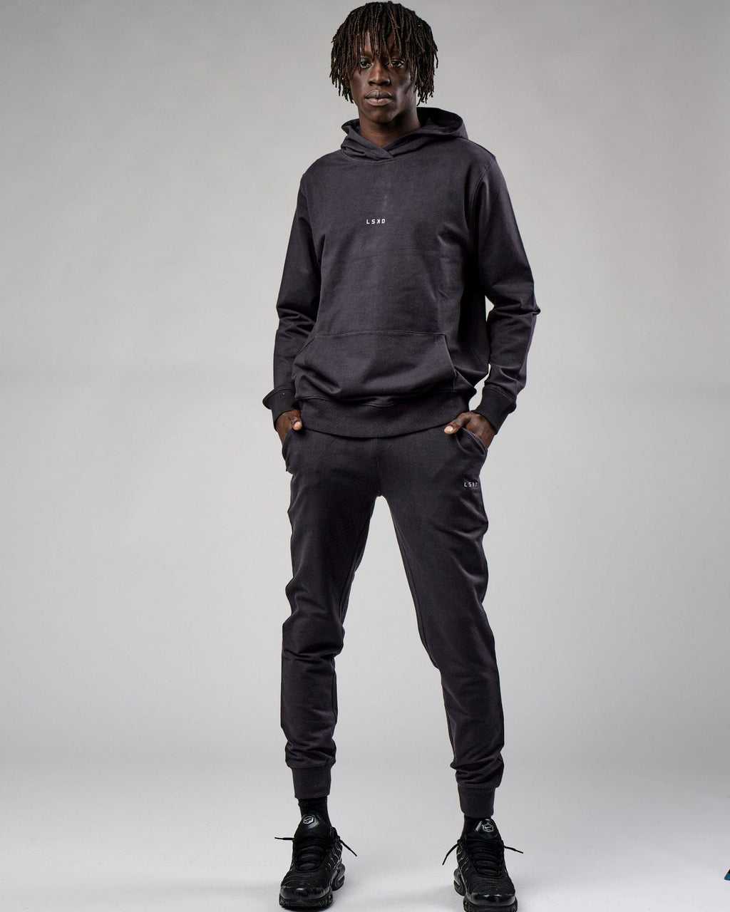 Model wearing Base Track Pant - Phantom