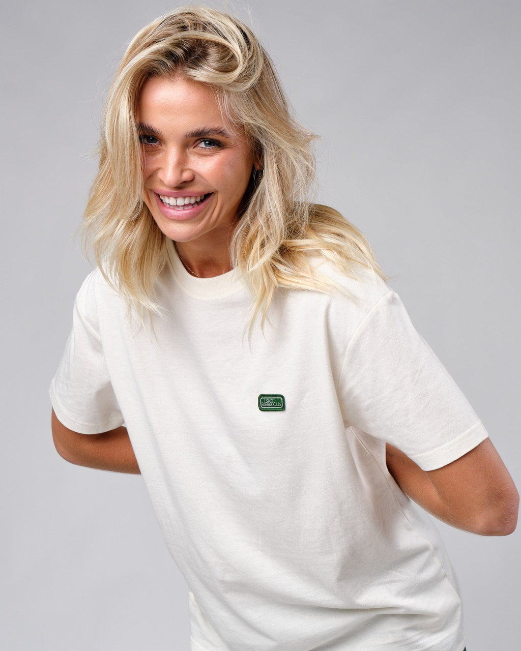 Model wearing Unisex Badge Tee Oversize - Cream