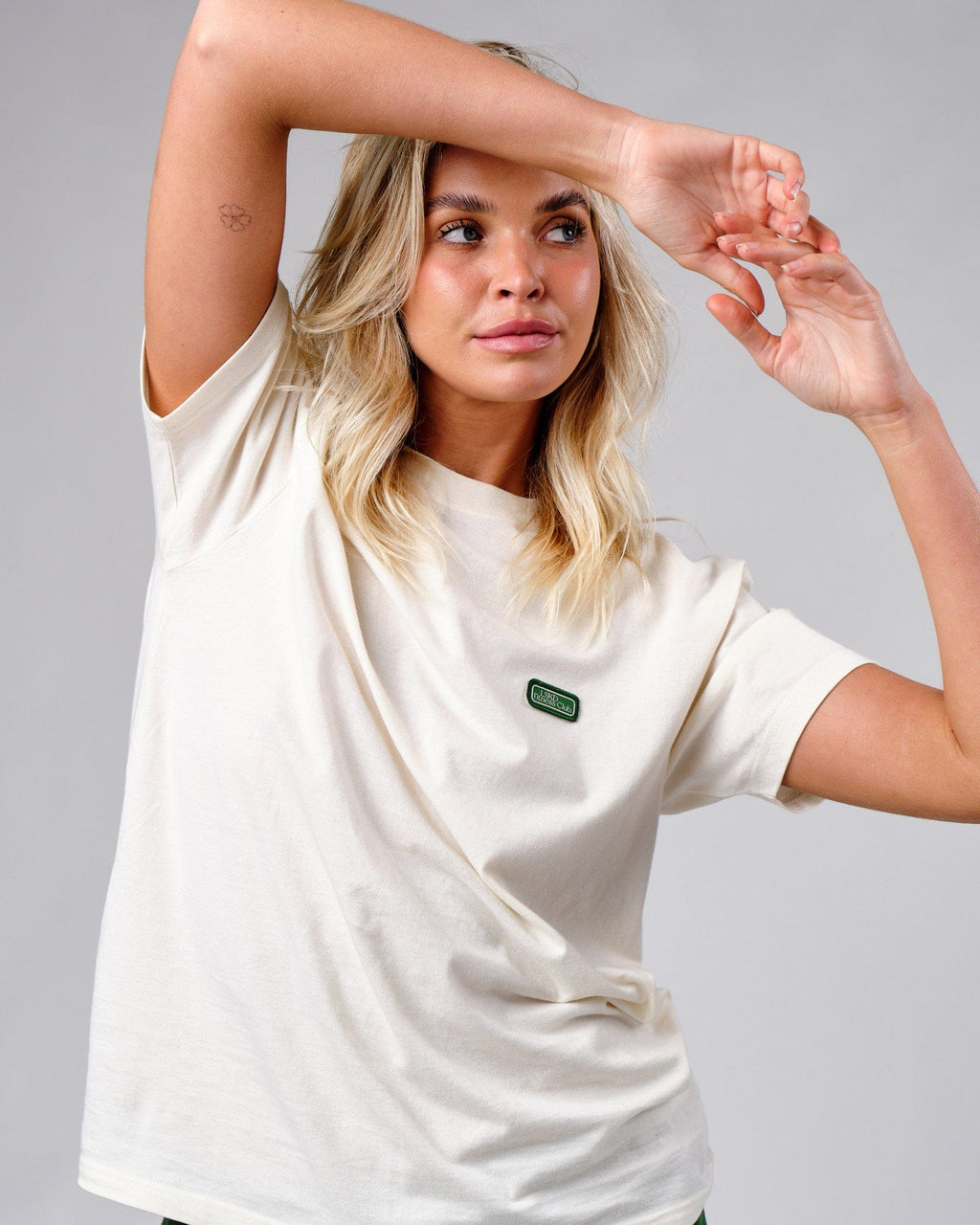 Model wearing Unisex Badge Tee Oversize - Cream