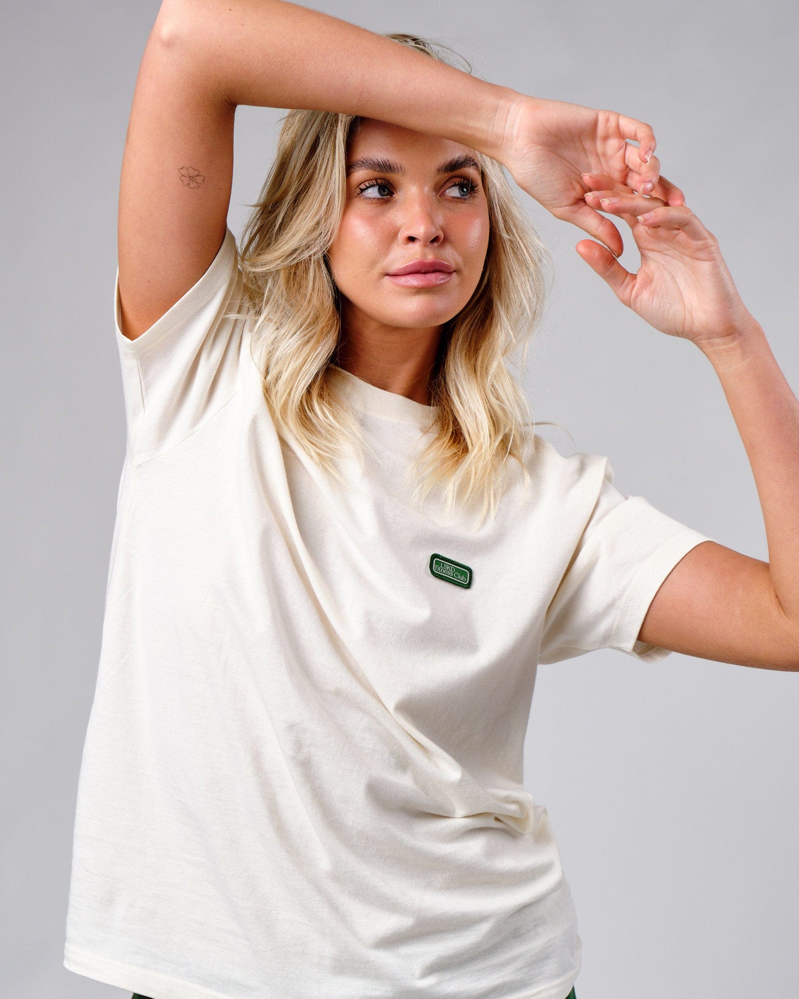 Model wearing Unisex Badge Tee Oversize - Cream
