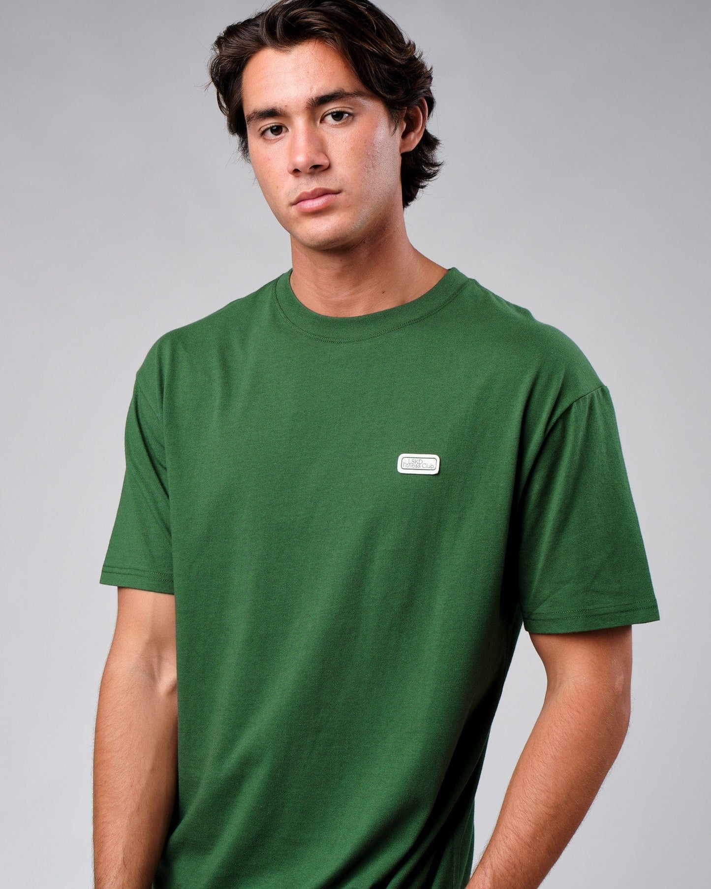 Model wearing Badge Tee Oversize - Eden Green