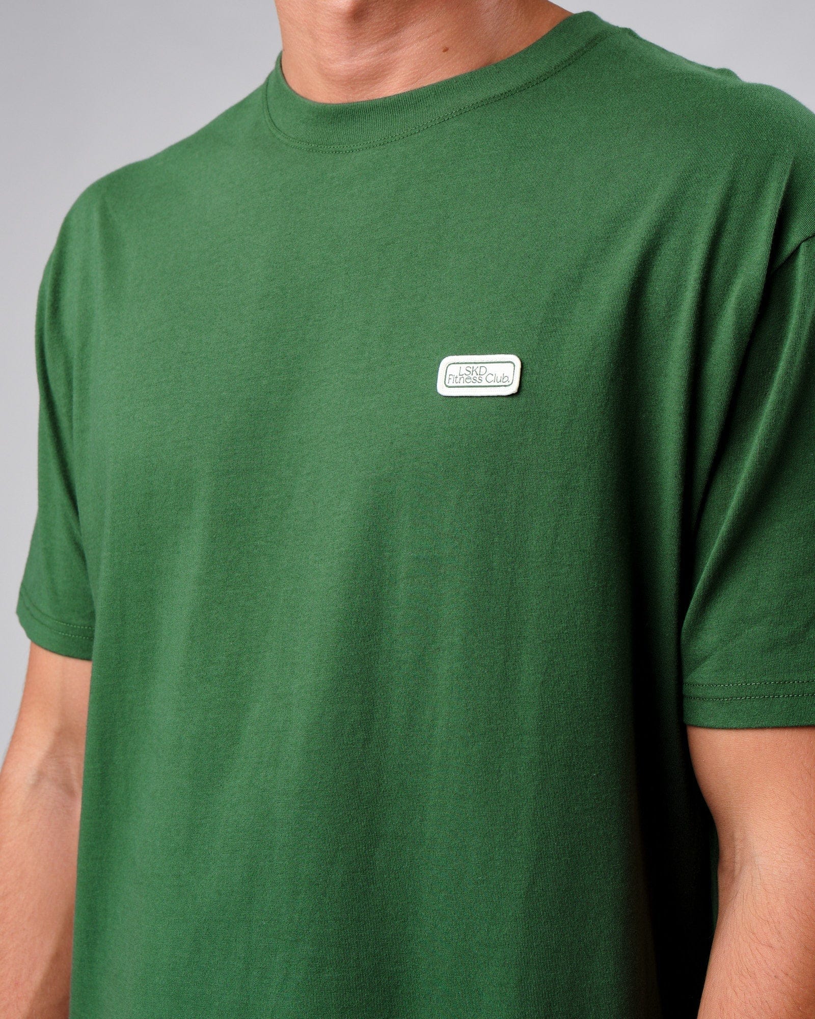 Model wearing Badge Tee Oversize - Eden Green