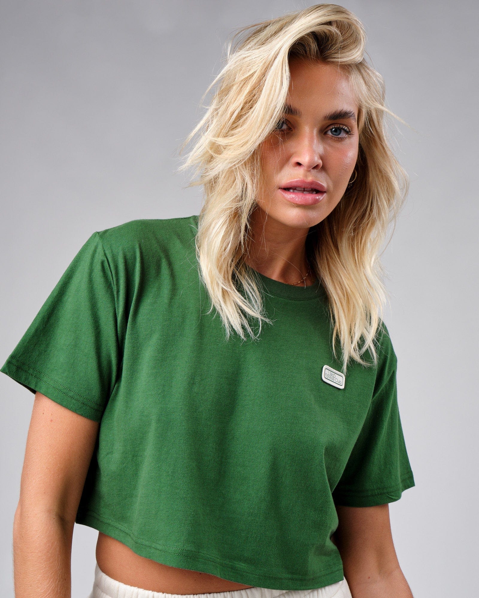 Model wearing Badge Tee - Eden Green