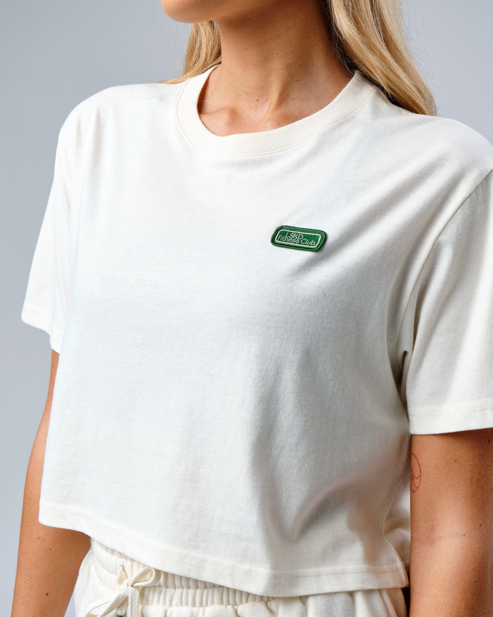 Model wearing Badge Tee - Cream