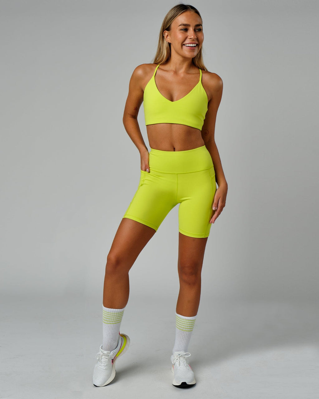 Model wearing Rep Mid Short Tight Small Logo - Fluro Lime