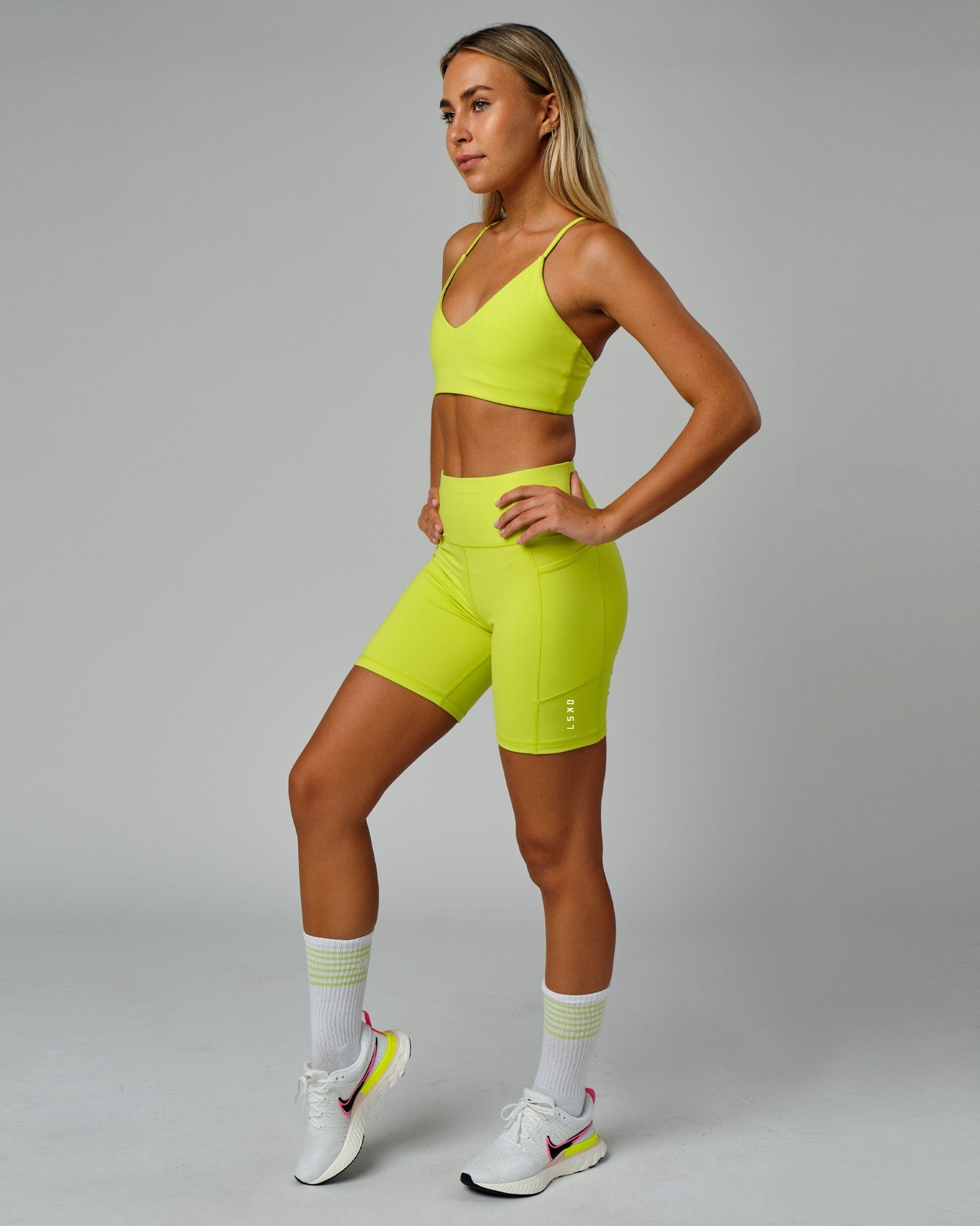 Model wearing Rep Mid Short Tight Small Logo - Fluro Lime