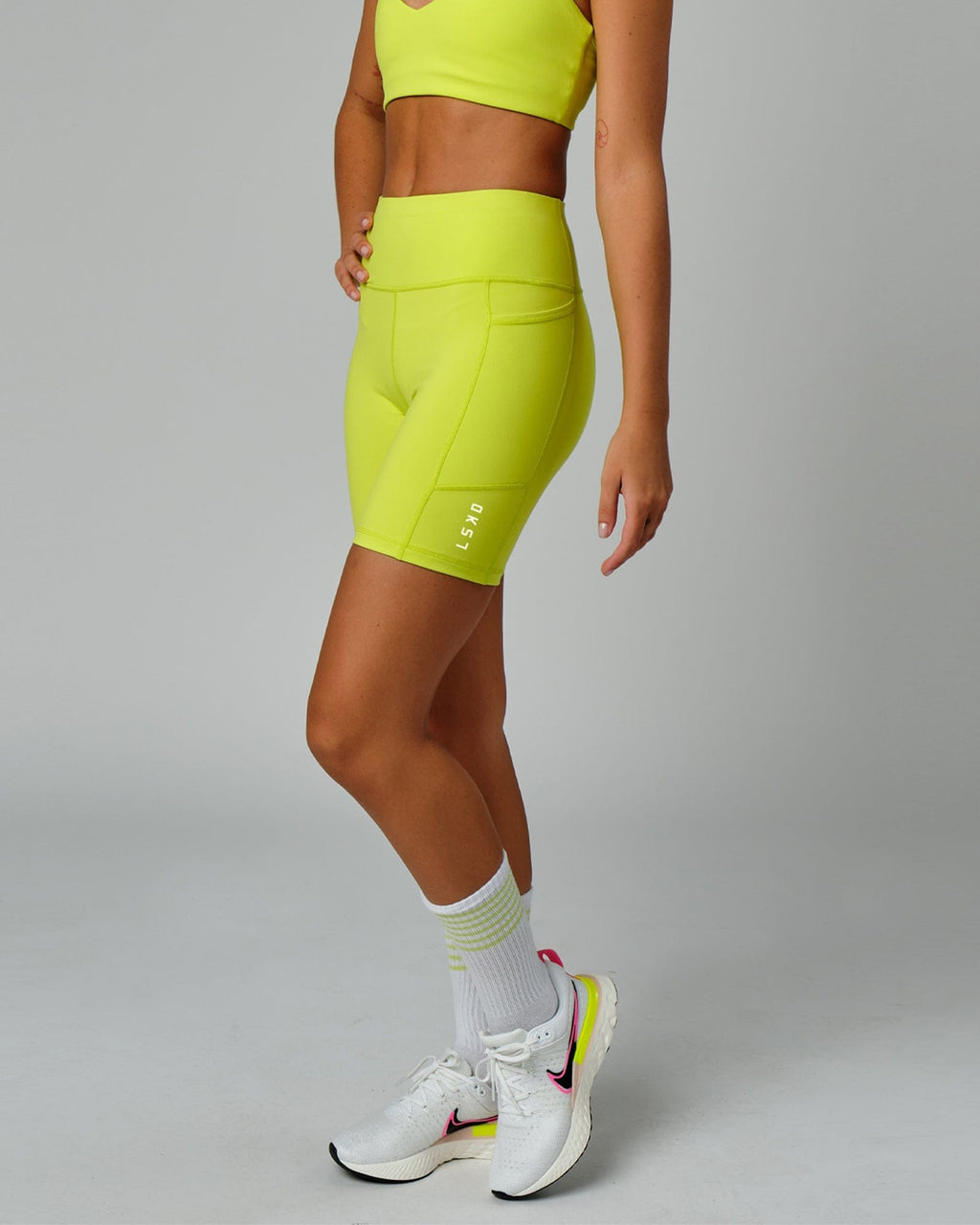 Model wearing Rep Mid Short Tight Small Logo - Fluro Lime