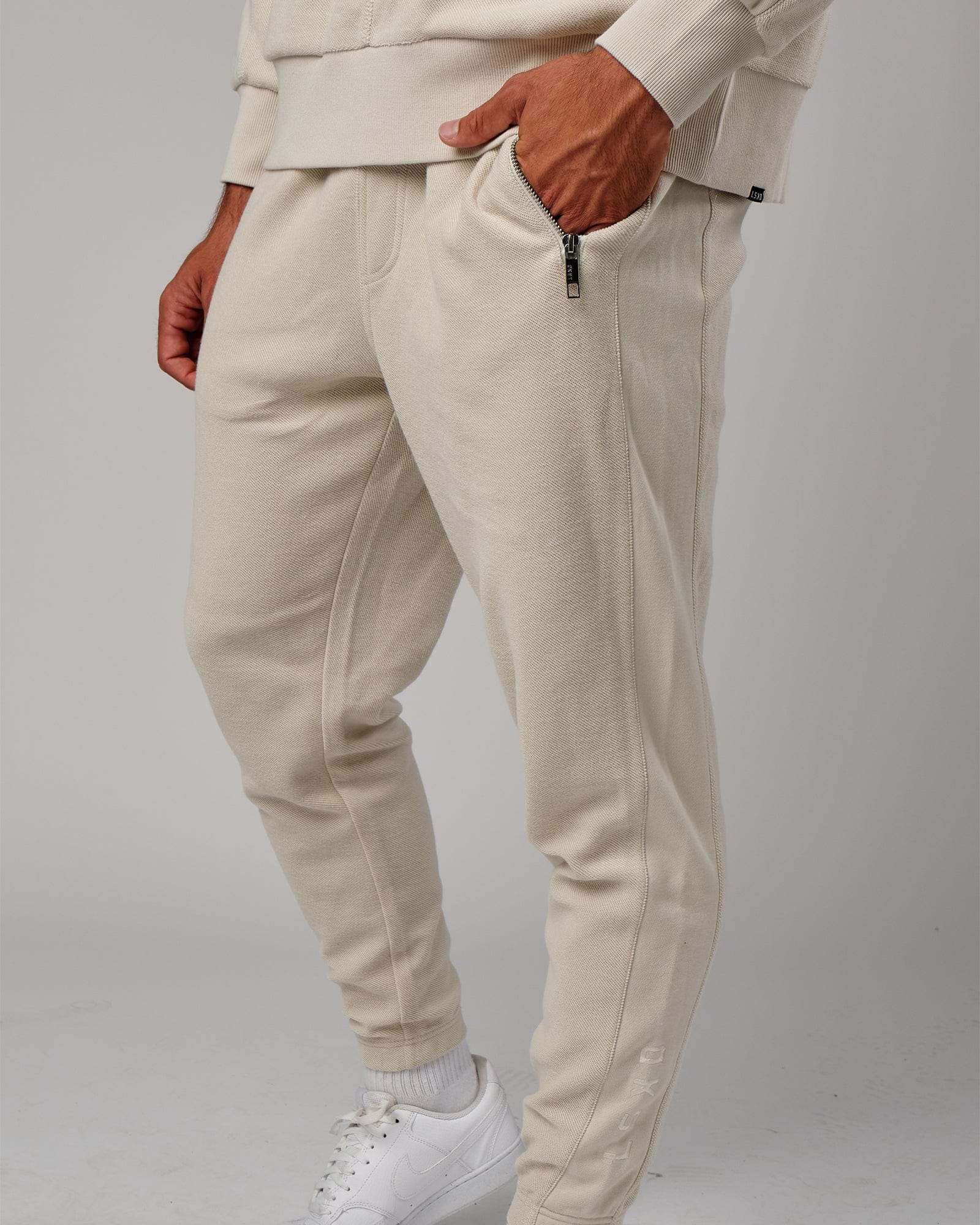 Model wearing Therma Track Pant - Bone