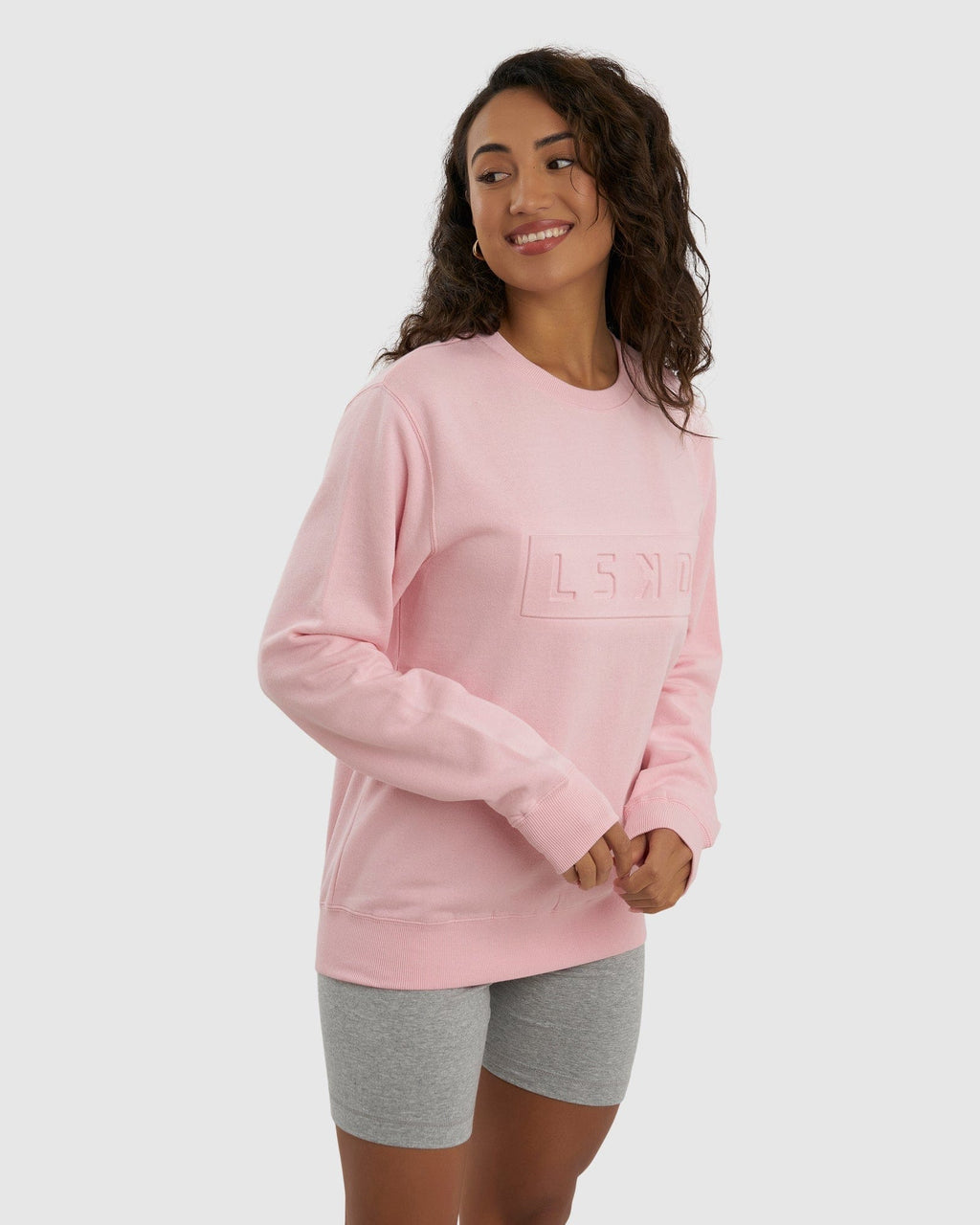 Model wearing Unisex Imprint Sweater - Petal Pink