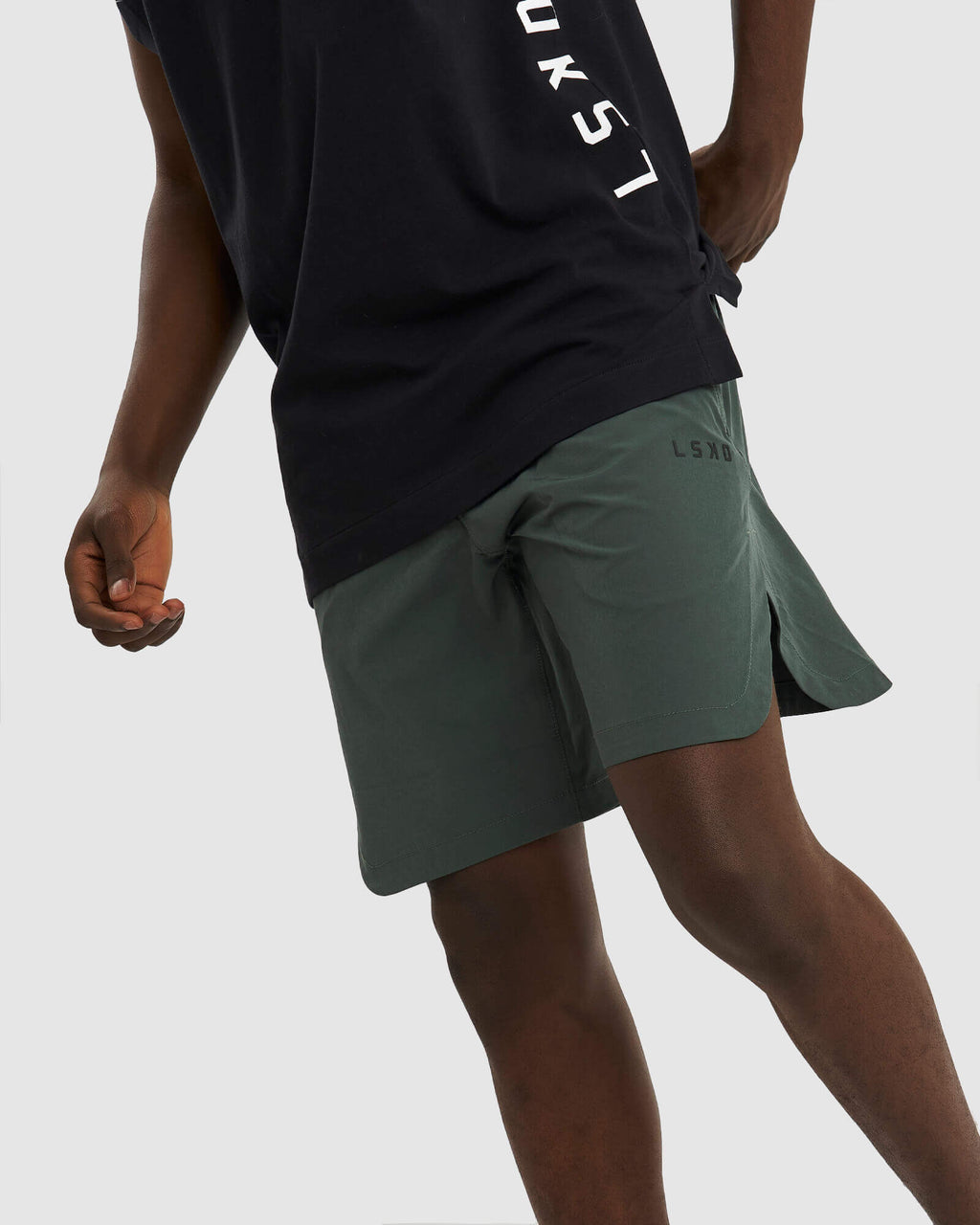 Model wearing Competition 8" Performance Short - Carbon Green