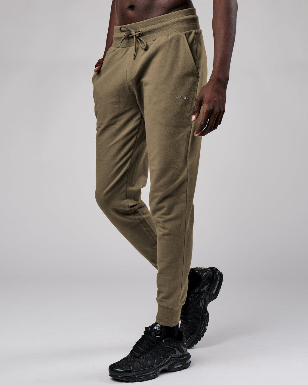Model wearing Base Track Pant - Walnut Grey