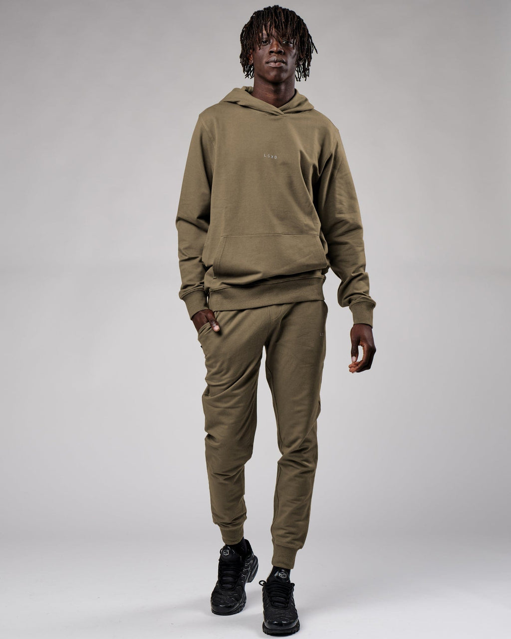 Model wearing Base Track Pant - Walnut Grey