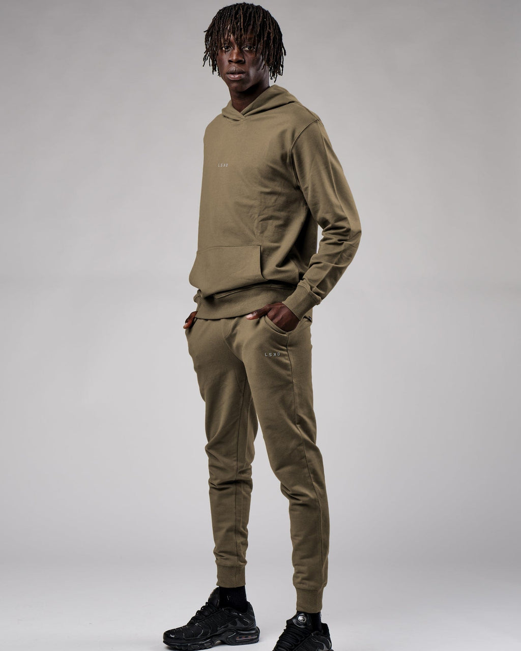 Model wearing Base Track Pant - Walnut Grey