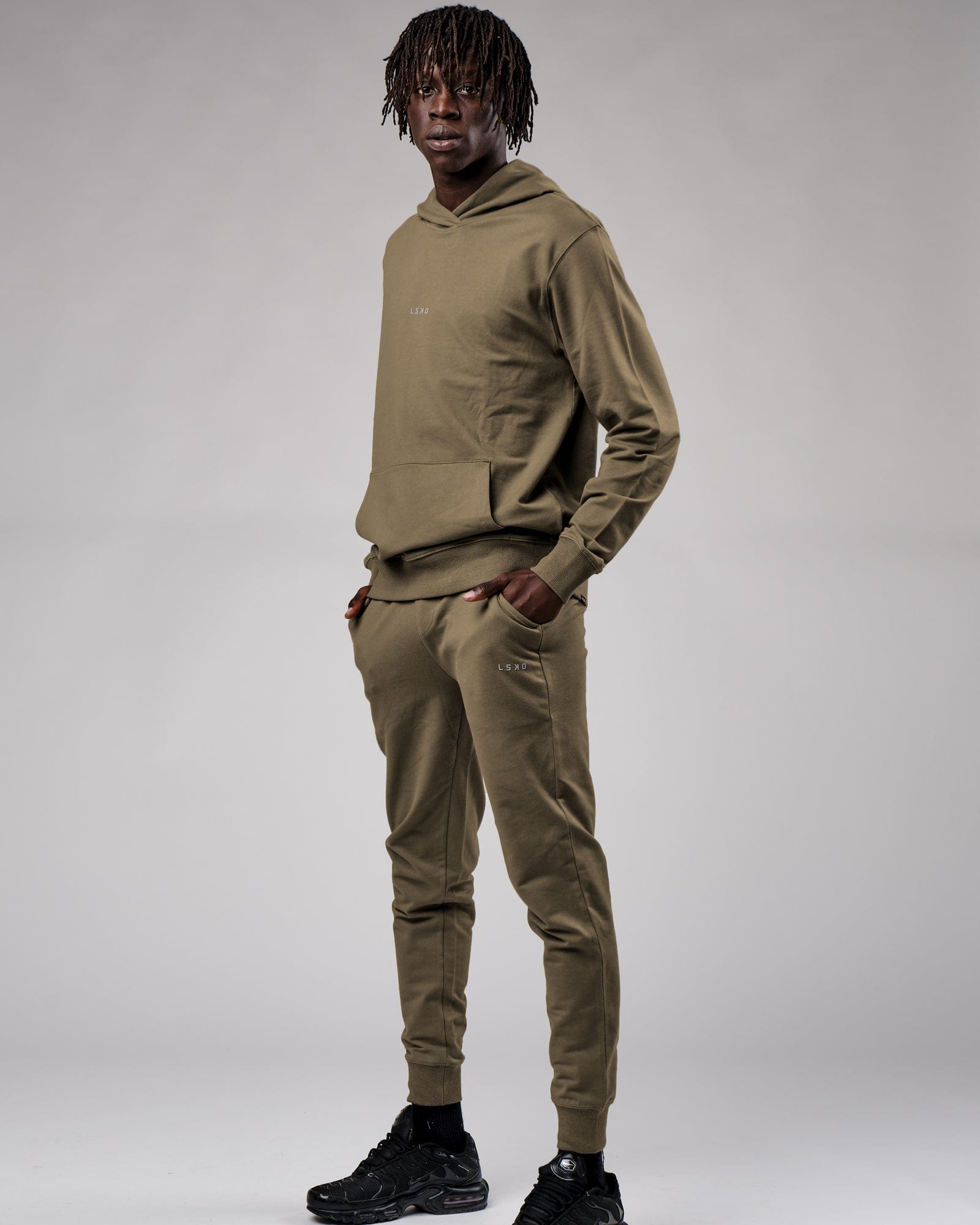 Model wearing Base Track Pant - Walnut Grey