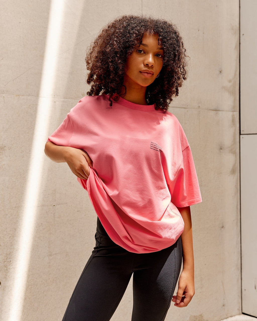 Model wearing Unisex Strive FLXCotton Tee Oversize - Sunkist Coral