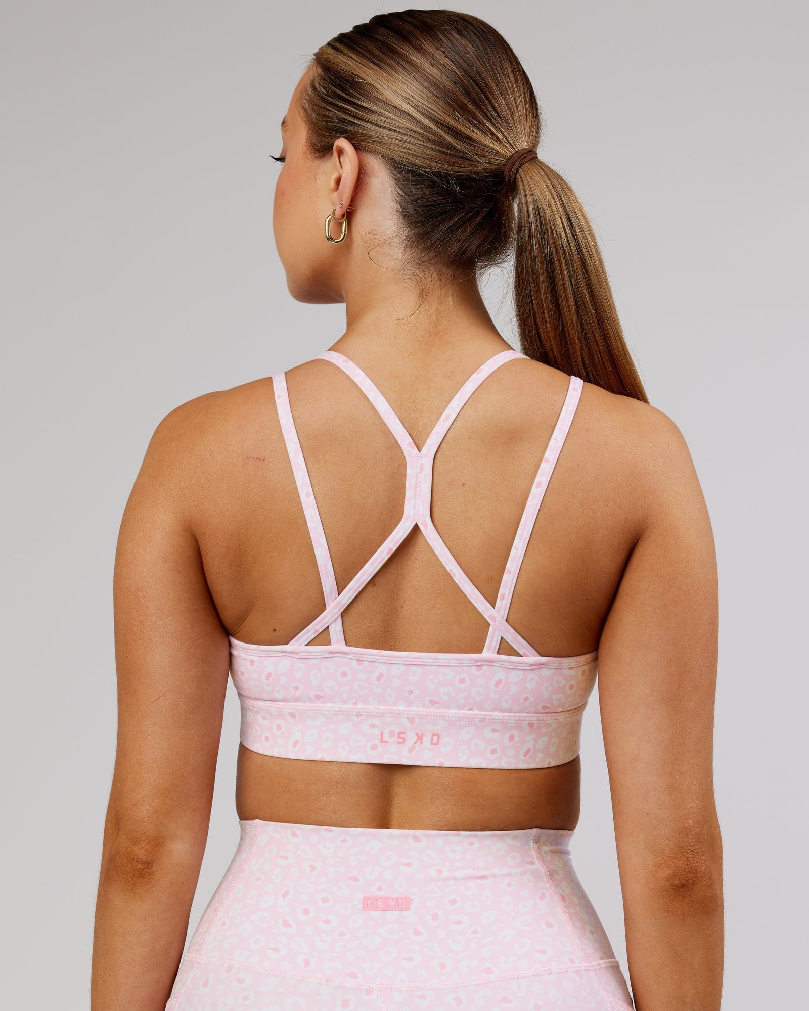 Model wearing Bridge Sports Bra - Blush Leopard