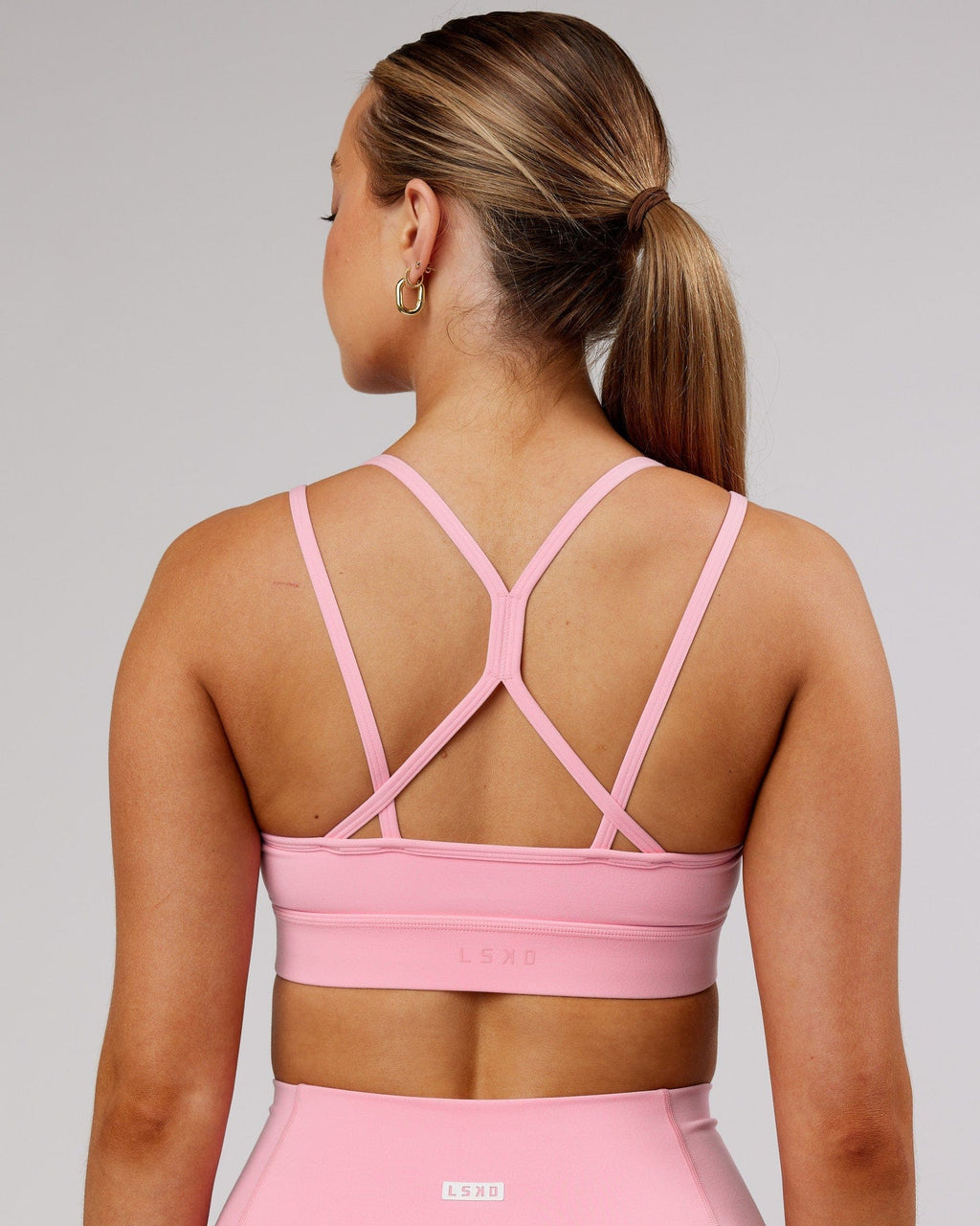 Model wearing Bridge Sports Bra - Pink Frosting