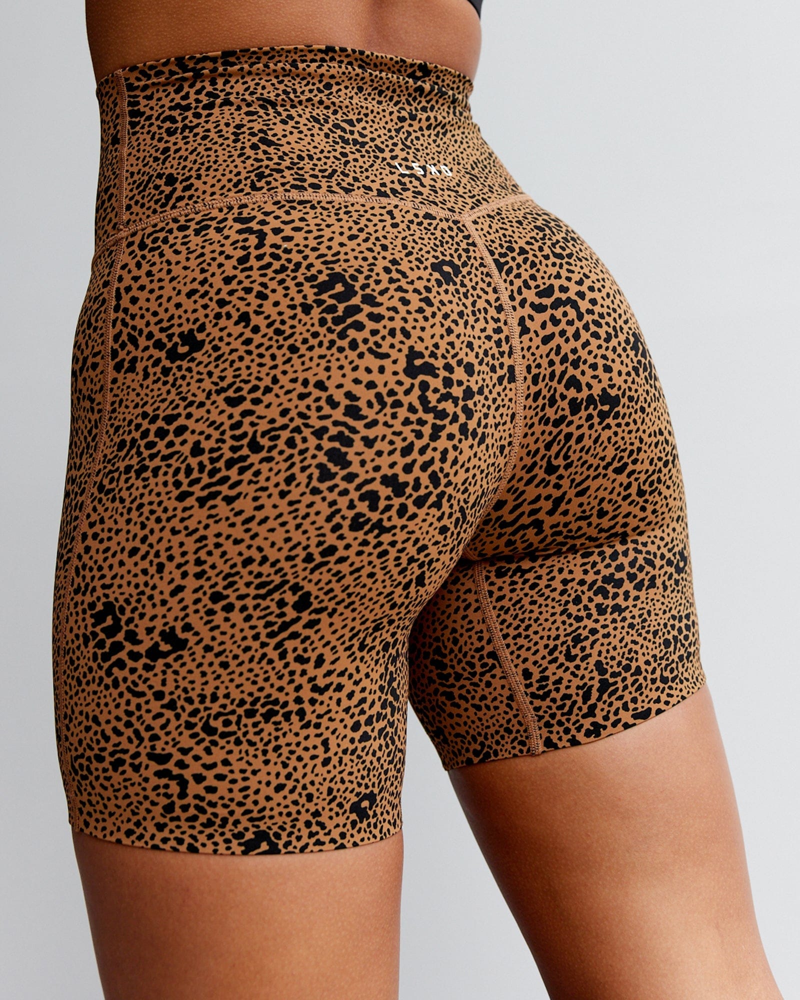 Model wearing Elixir Mid Short Tight - Agile Camel Print