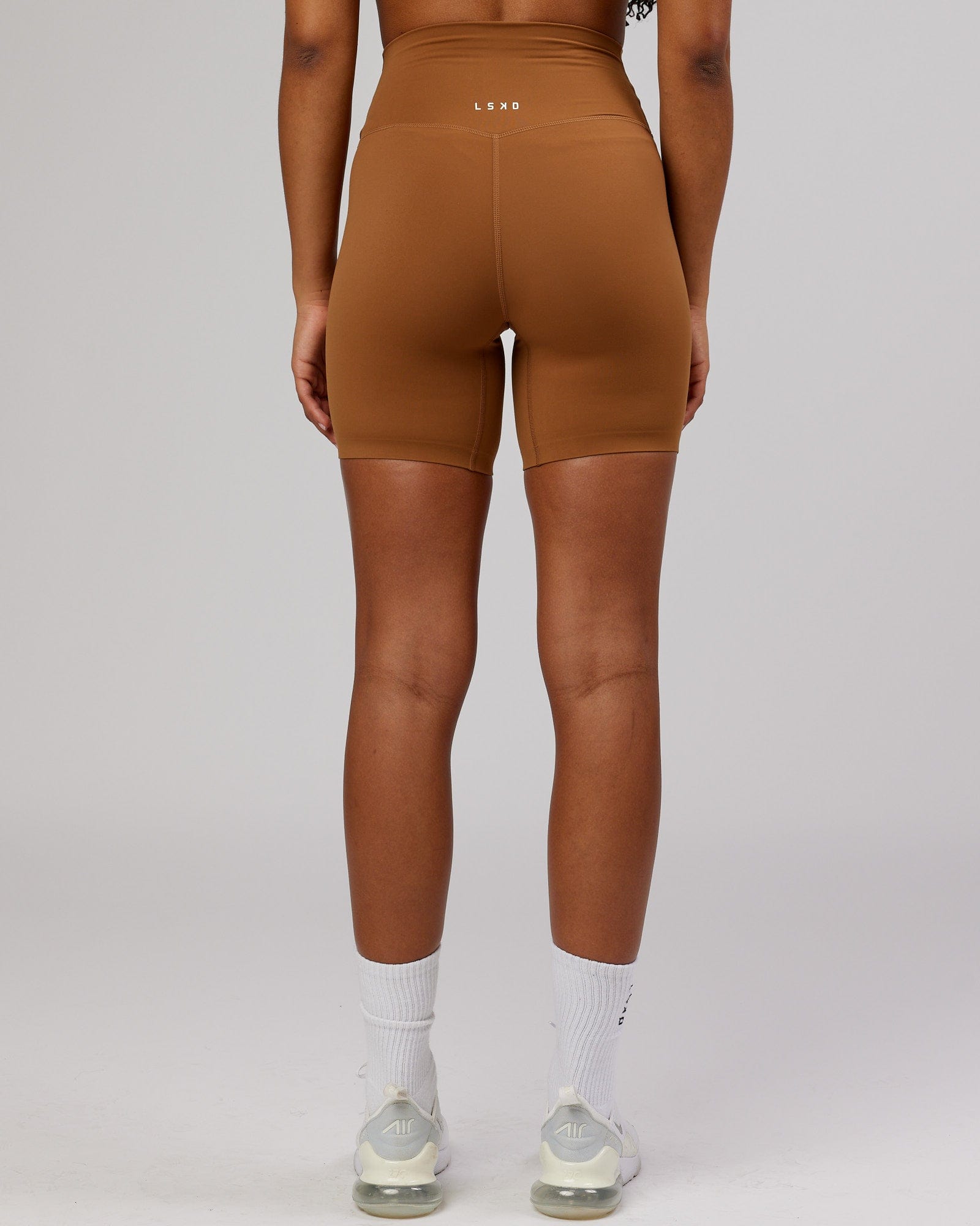 Model wearing Elixir Mid Short Tight - Camel
