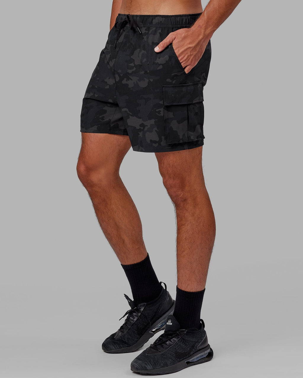 Model wearing Energy Stretch Performance Cargo Short - Black Camo