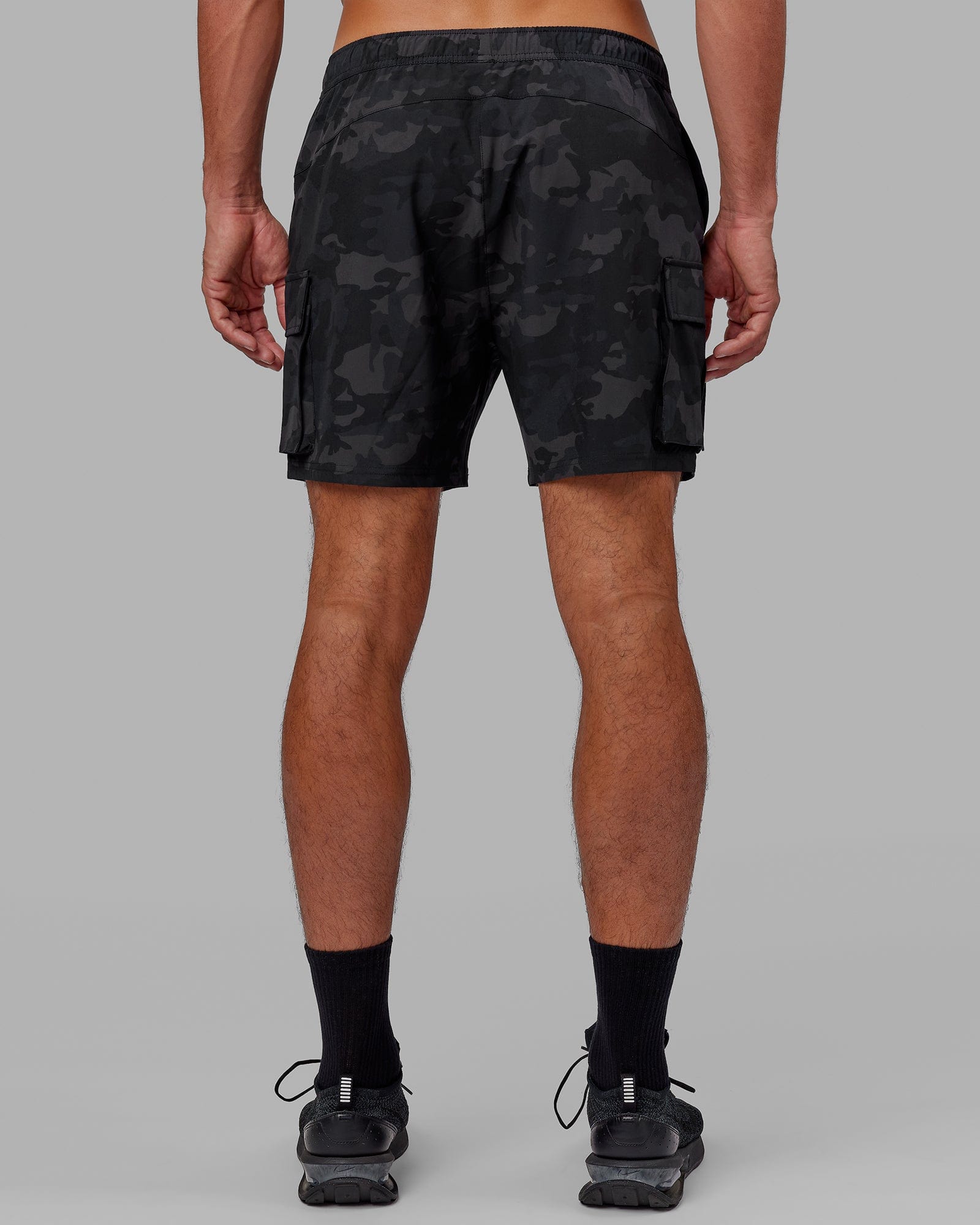 Model wearing Energy Stretch Performance Cargo Short - Black Camo