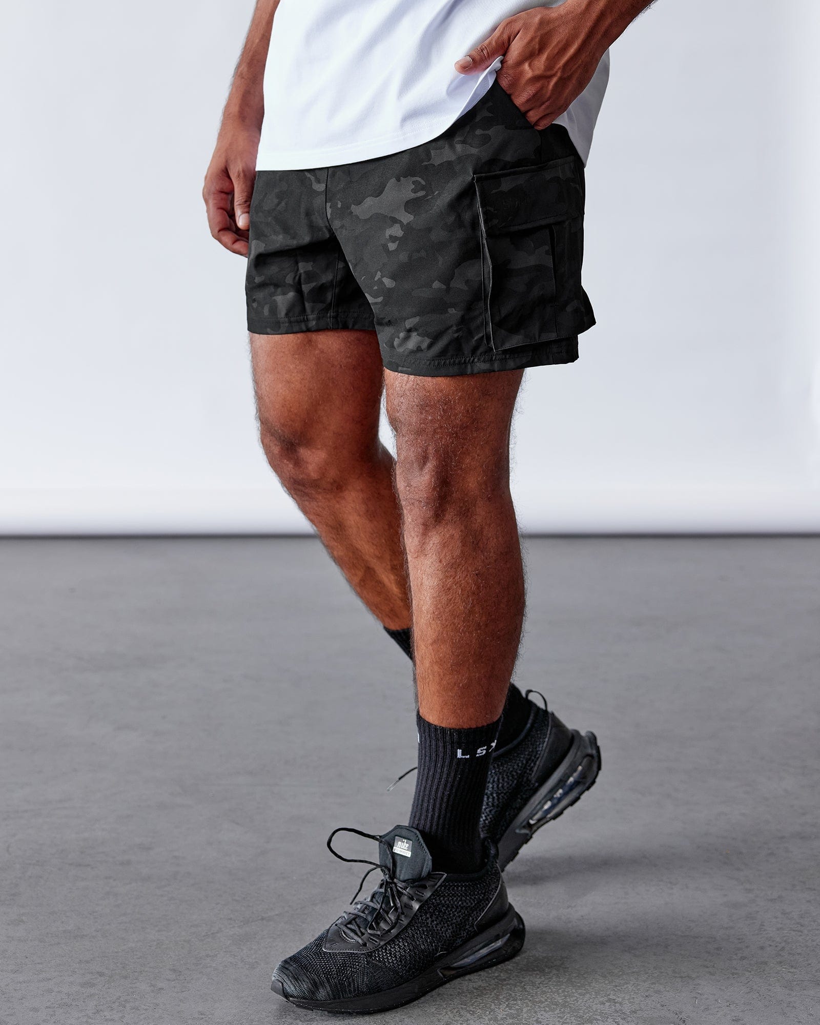 Model wearing Energy Stretch Performance Cargo Short - Black Camo