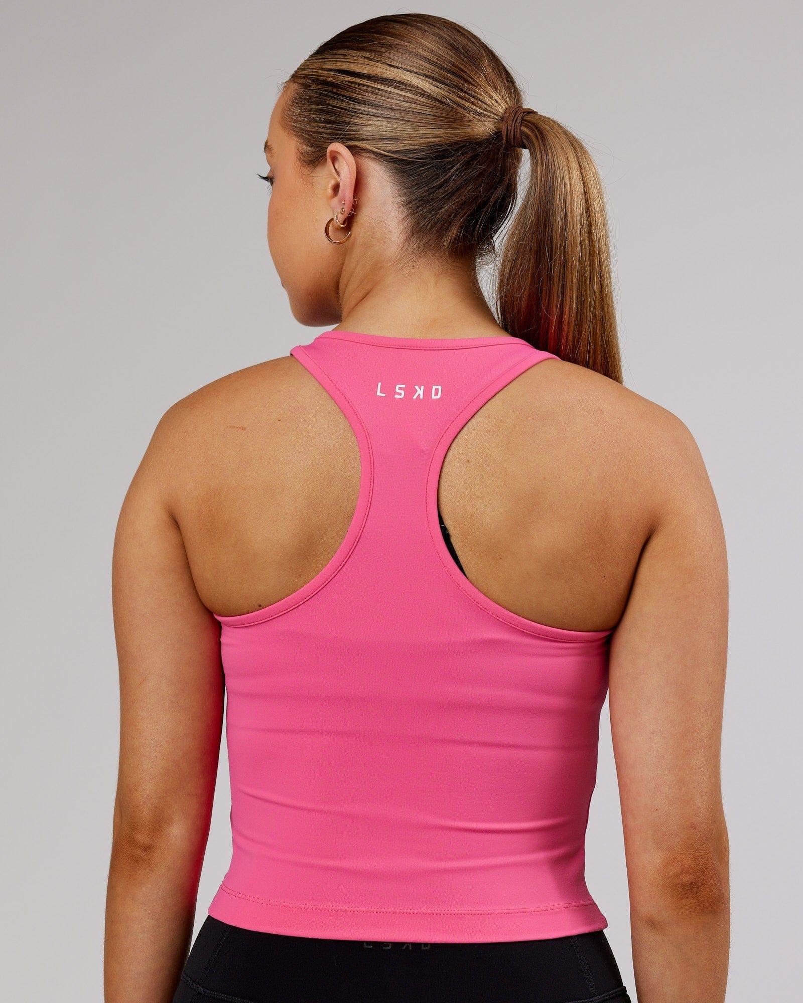 Model wearing Flow Performance Tank - Flamingo