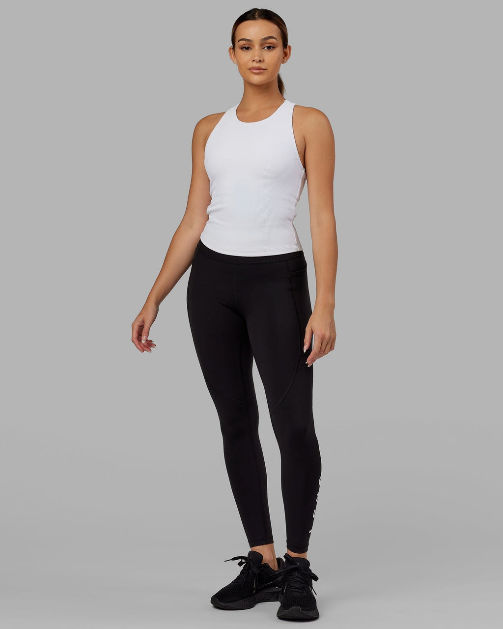 Model wearing Flow Ribbed Shelf Bra Performance Tank - White