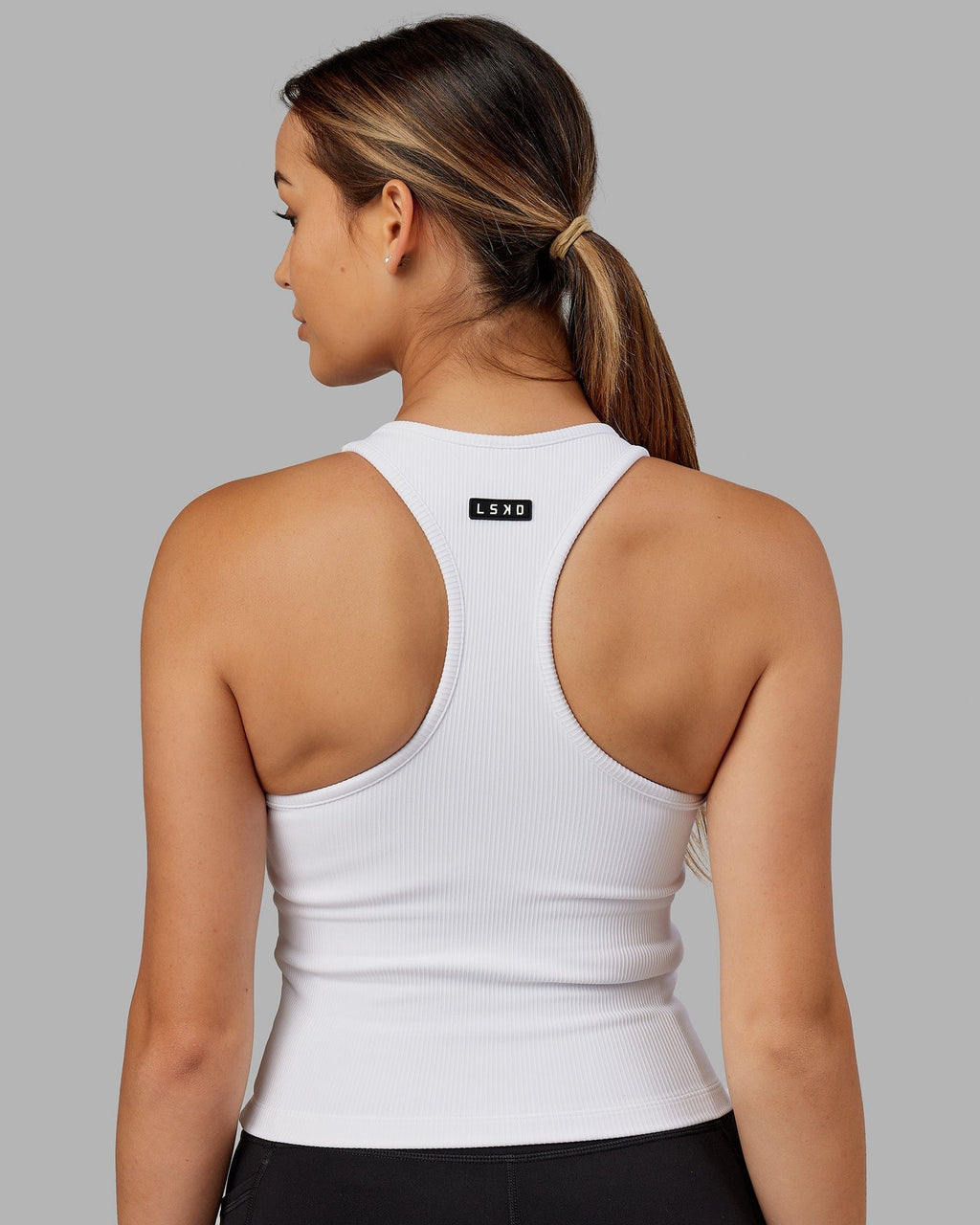 Model wearing Flow Ribbed Shelf Bra Performance Tank - White