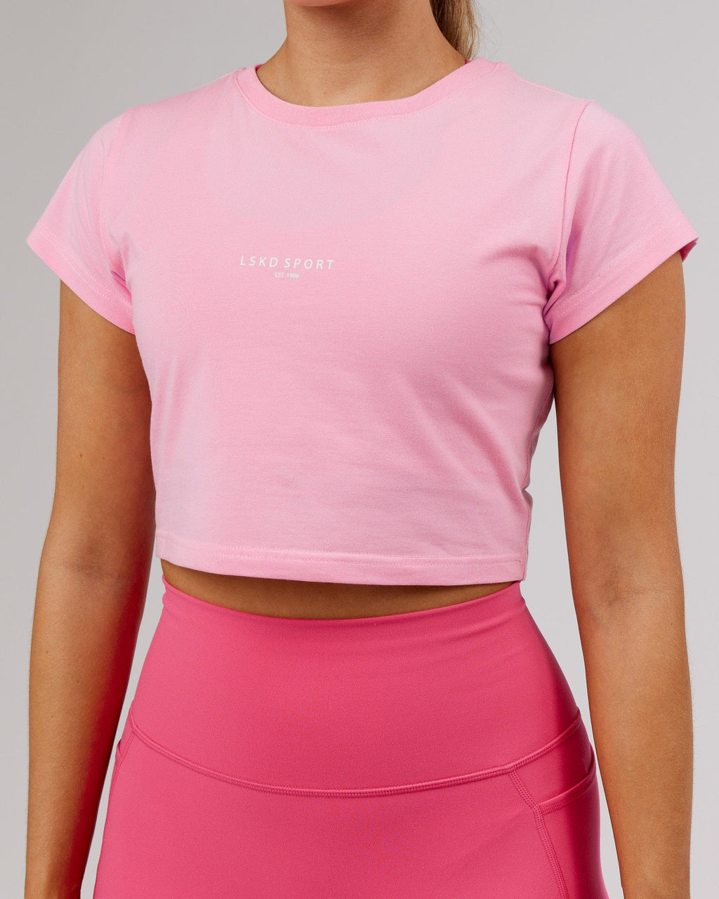 Model wearing Front Runner Baby Tee - Pink Frosting