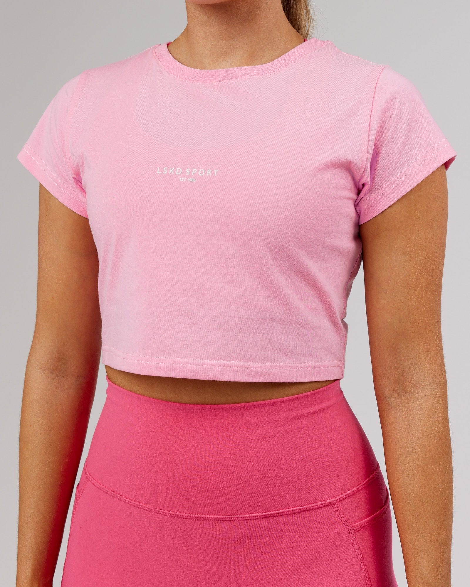 Model wearing Front Runner Baby Tee - Pink Frosting