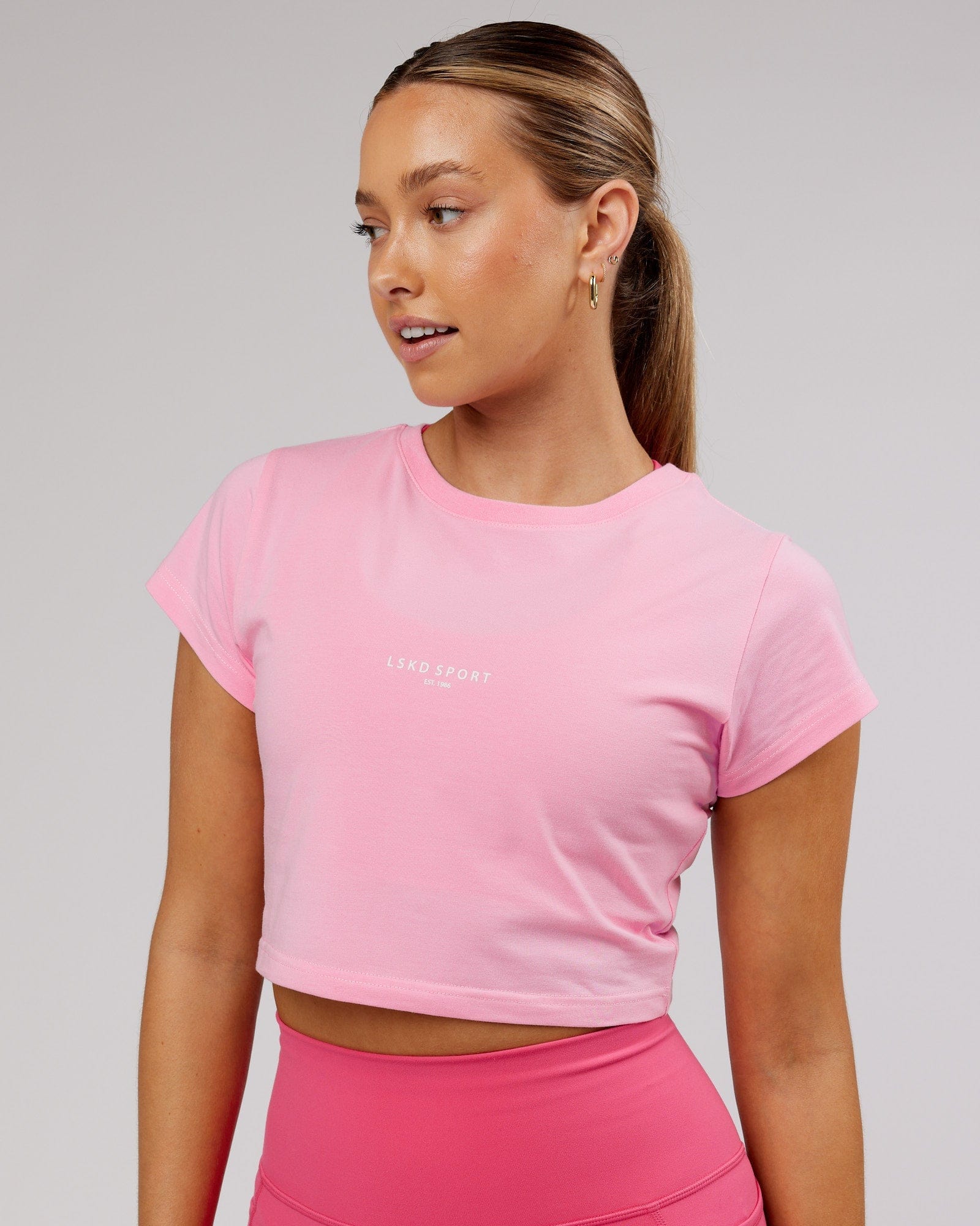 Model wearing Front Runner Baby Tee - Pink Frosting