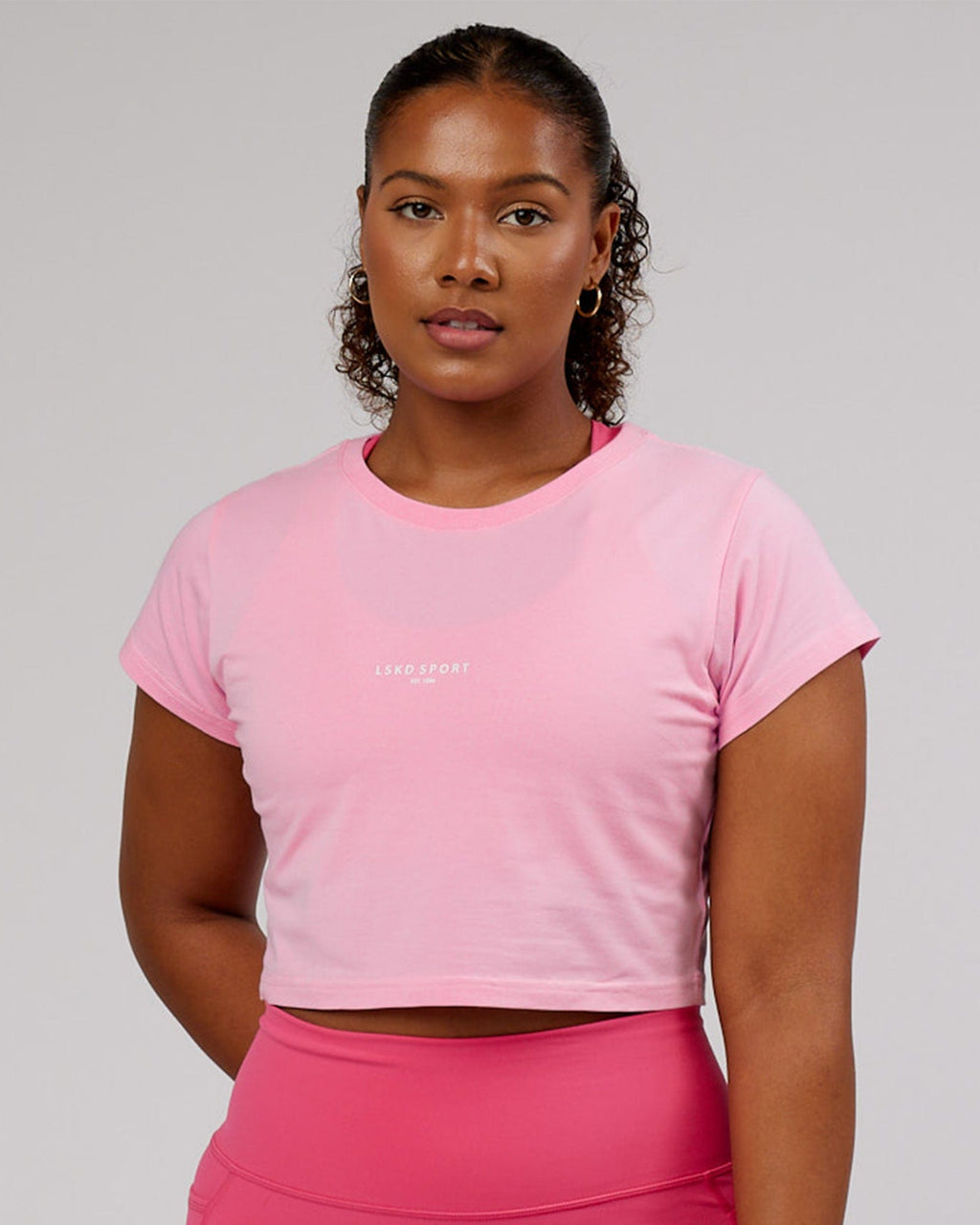 Model wearing Front Runner Baby Tee - Pink Frosting