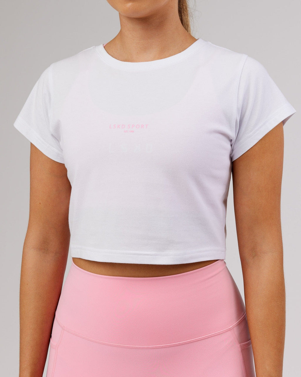 Model wearing Front Runner Baby Tee - White-Pink Frosting