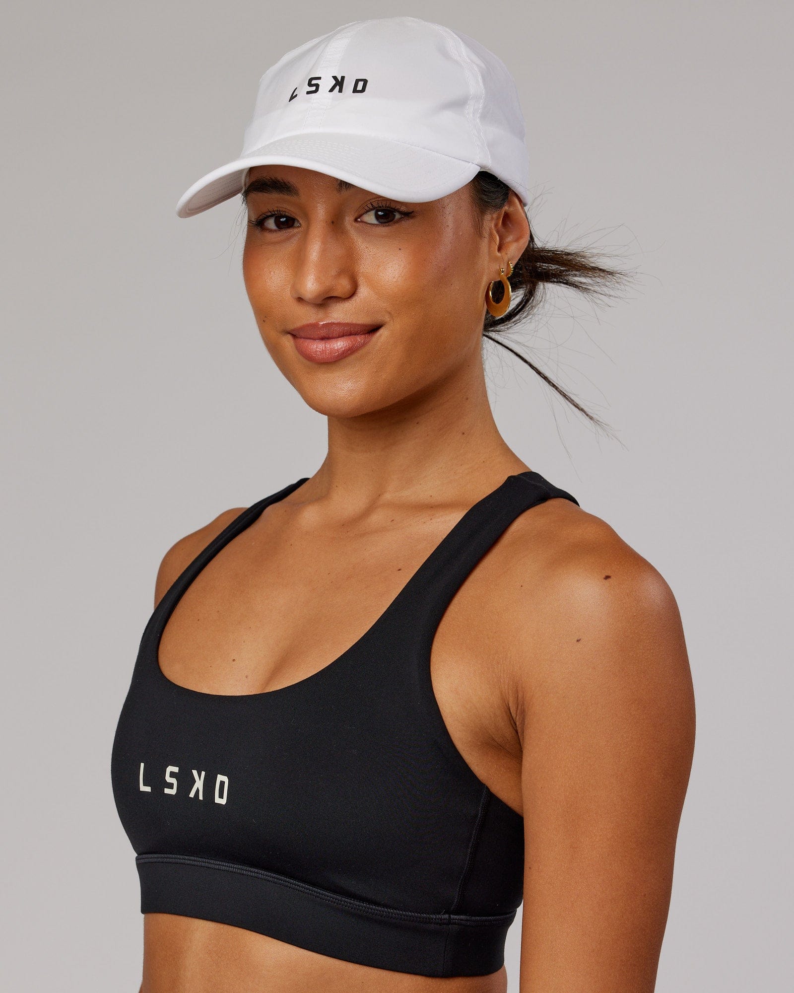 Model wearing Performance Tech Cap - White